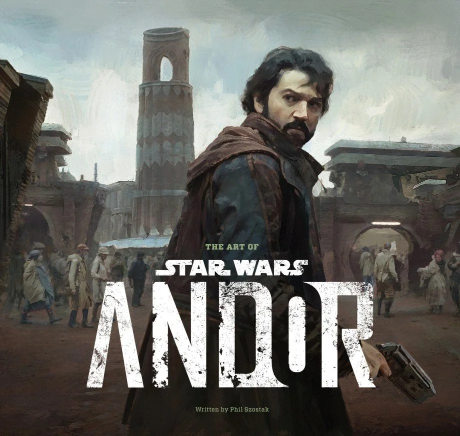 Artwork of a Star Wars-themed book titled 'The Art of Star Wars: Andor' by Phil Szostak, featuring a man with dark hair and a beard in a brown jacket, holding a blaster, in a futuristic, dystopian cityscape with large buildings and people walking in the background.