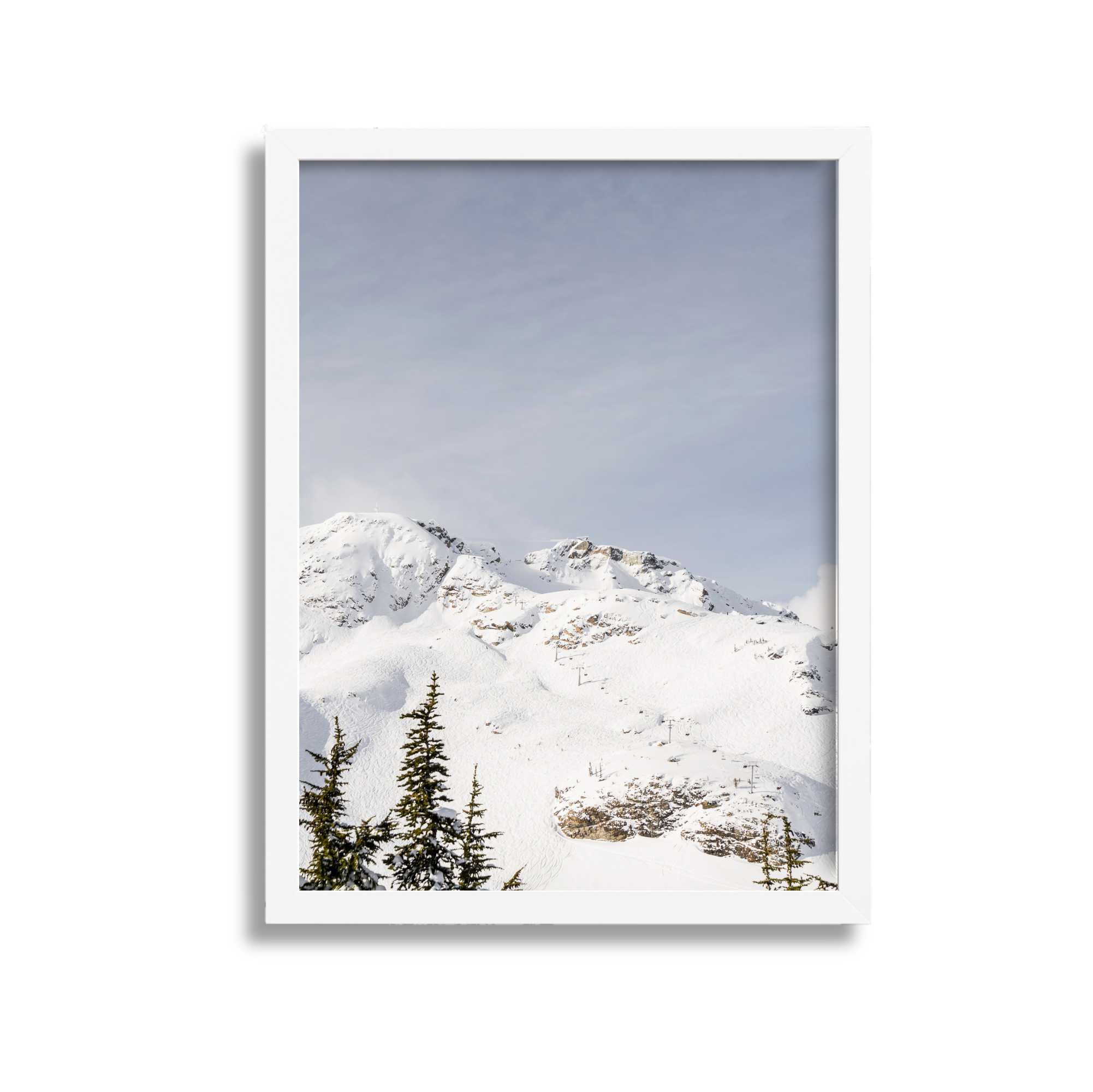 Snow-covered mountain landscape with evergreen trees in the foreground under a cloudy sky.
