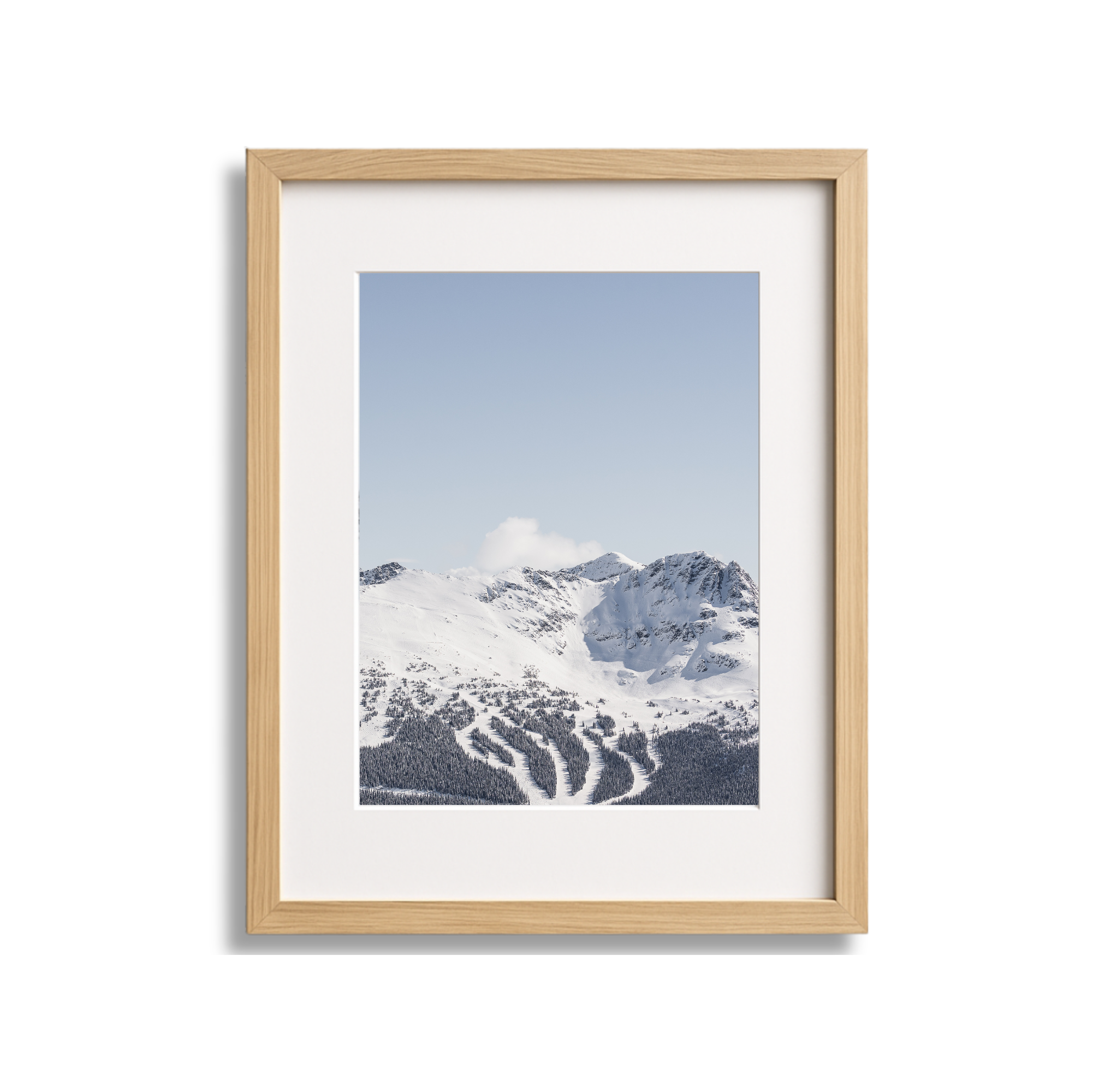 Framed photograph of snowy mountains under a clear blue sky.