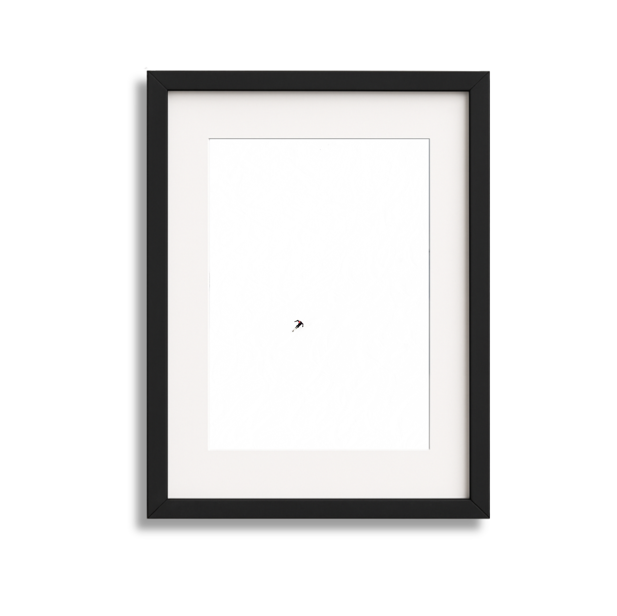 A framed minimalist art piece with a tiny black tree in the center against a white background.