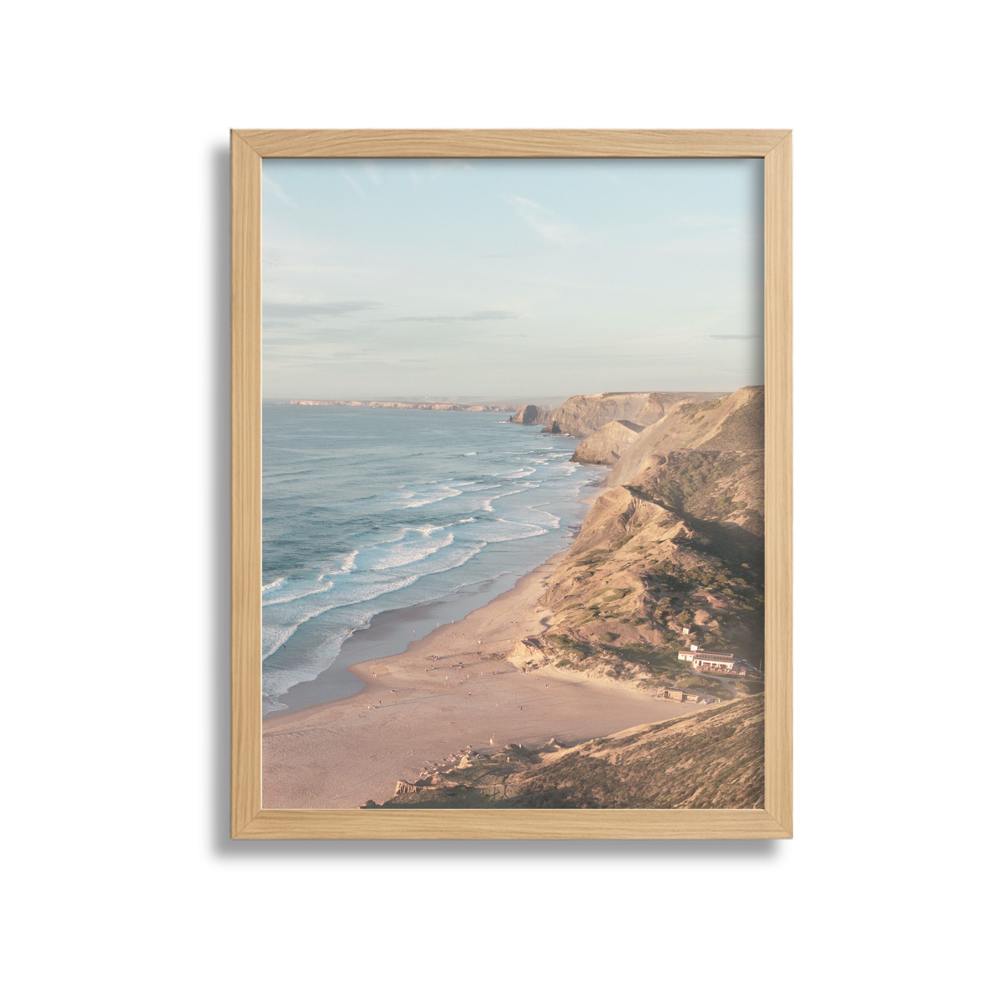 A framed photograph of a coastal scene with cliffs and the ocean, taken during daylight hours.