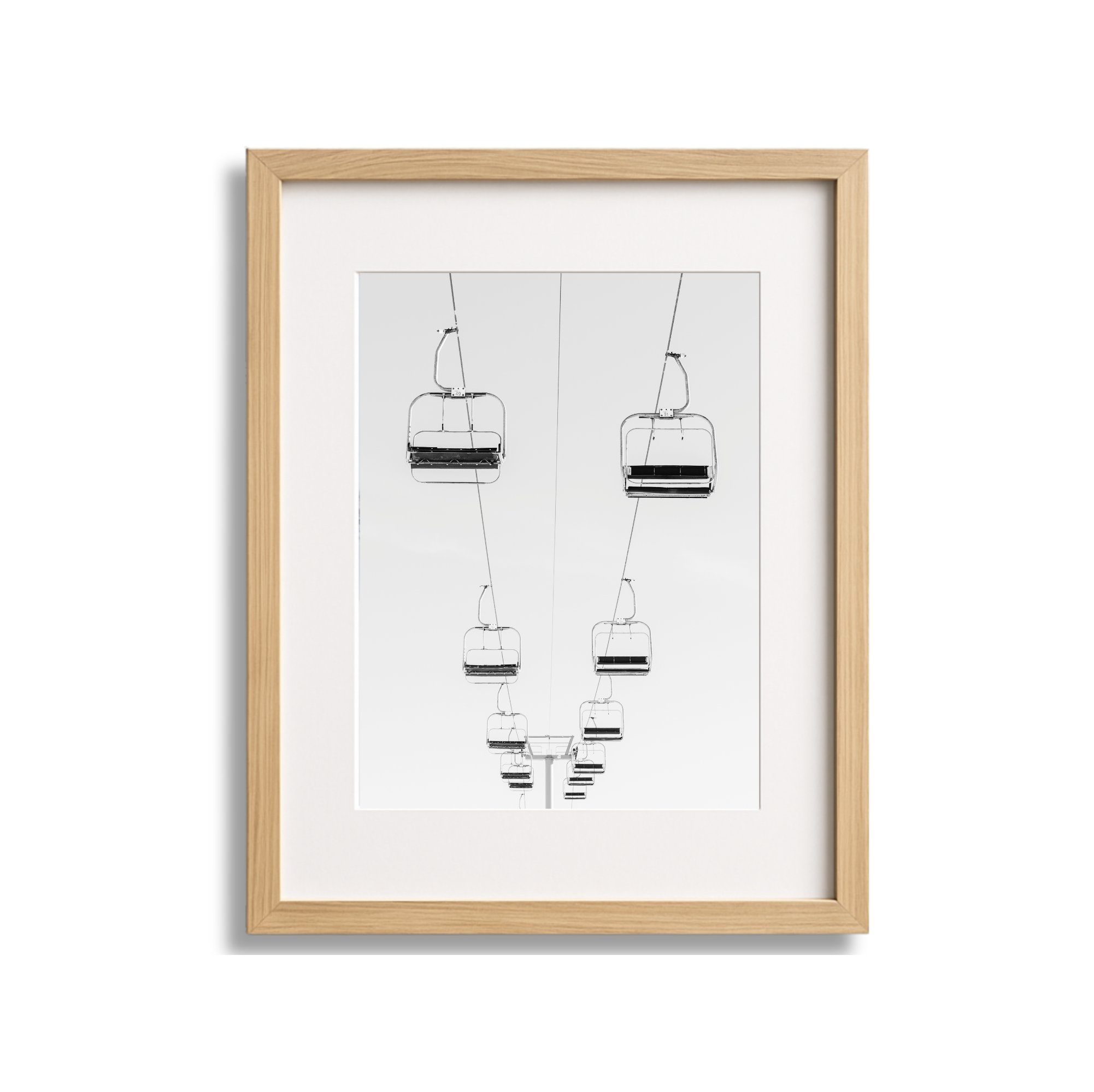 Frame with black and white sketch of ski lift chairs and cables.