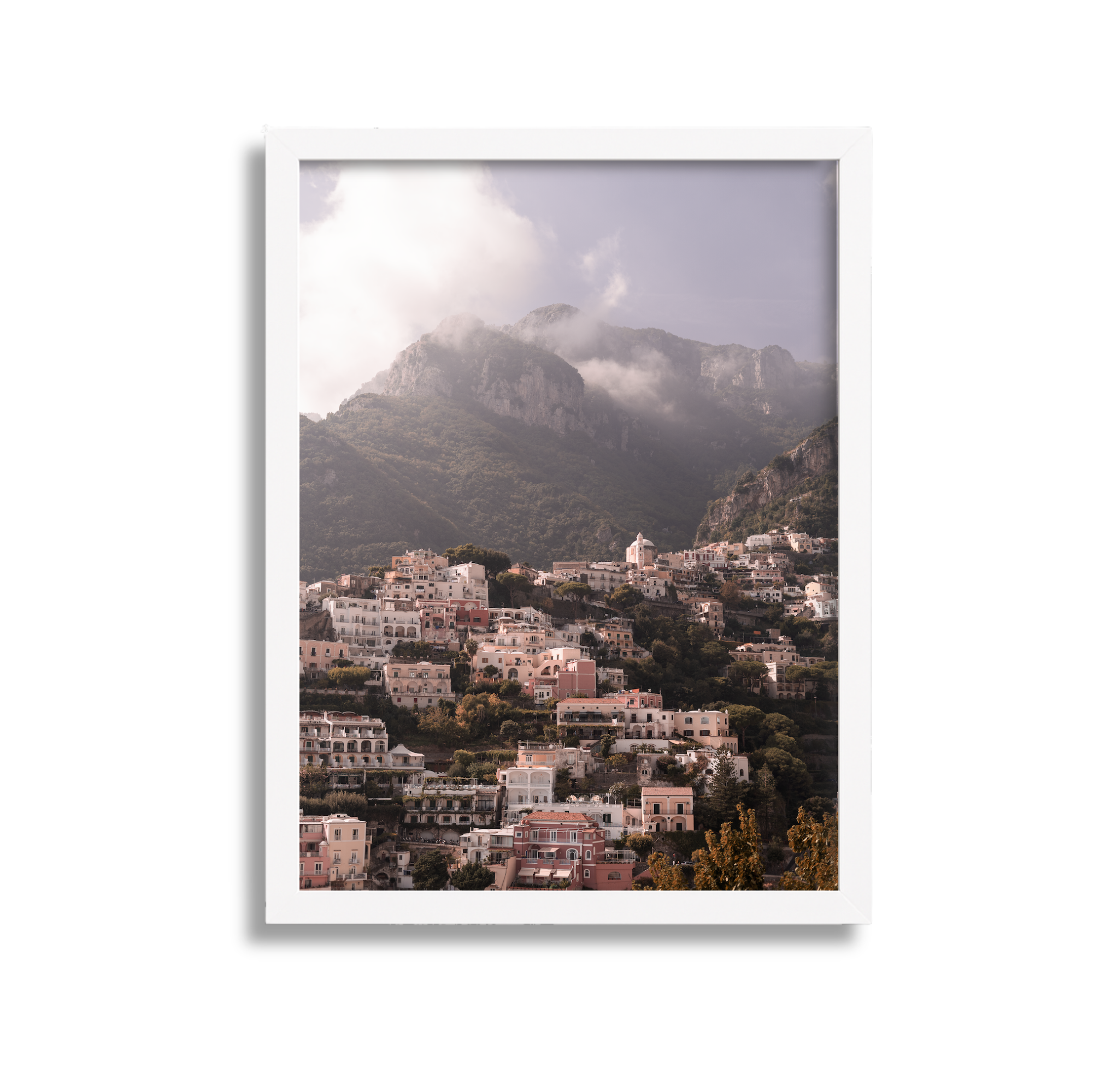 Mountain village with pastel-colored buildings on a hillside, mountains in the background shrouded in clouds.