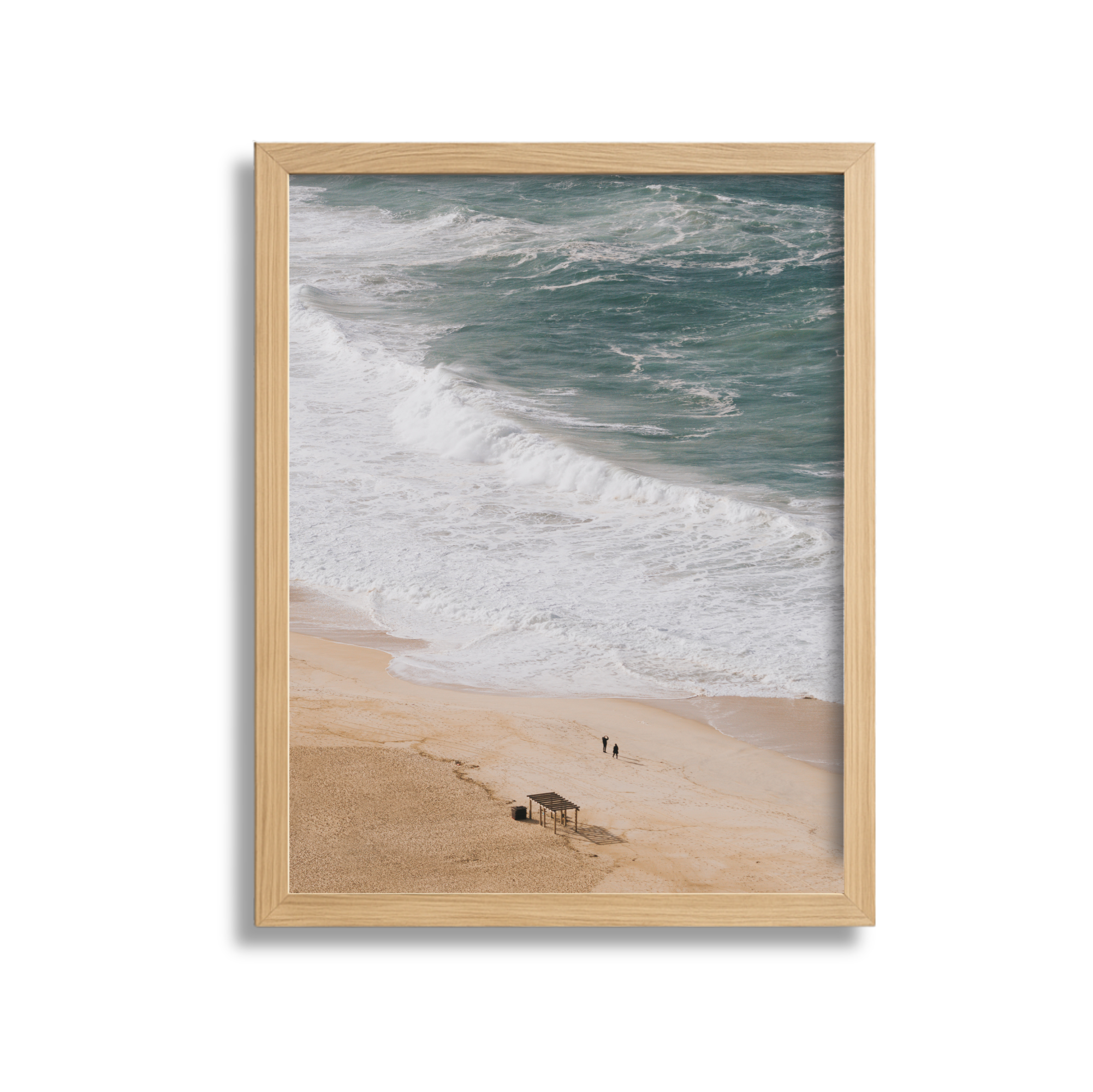 Beach scene with ocean waves, sandy shore, and two people walking along the beach, framed in a wooden frame.