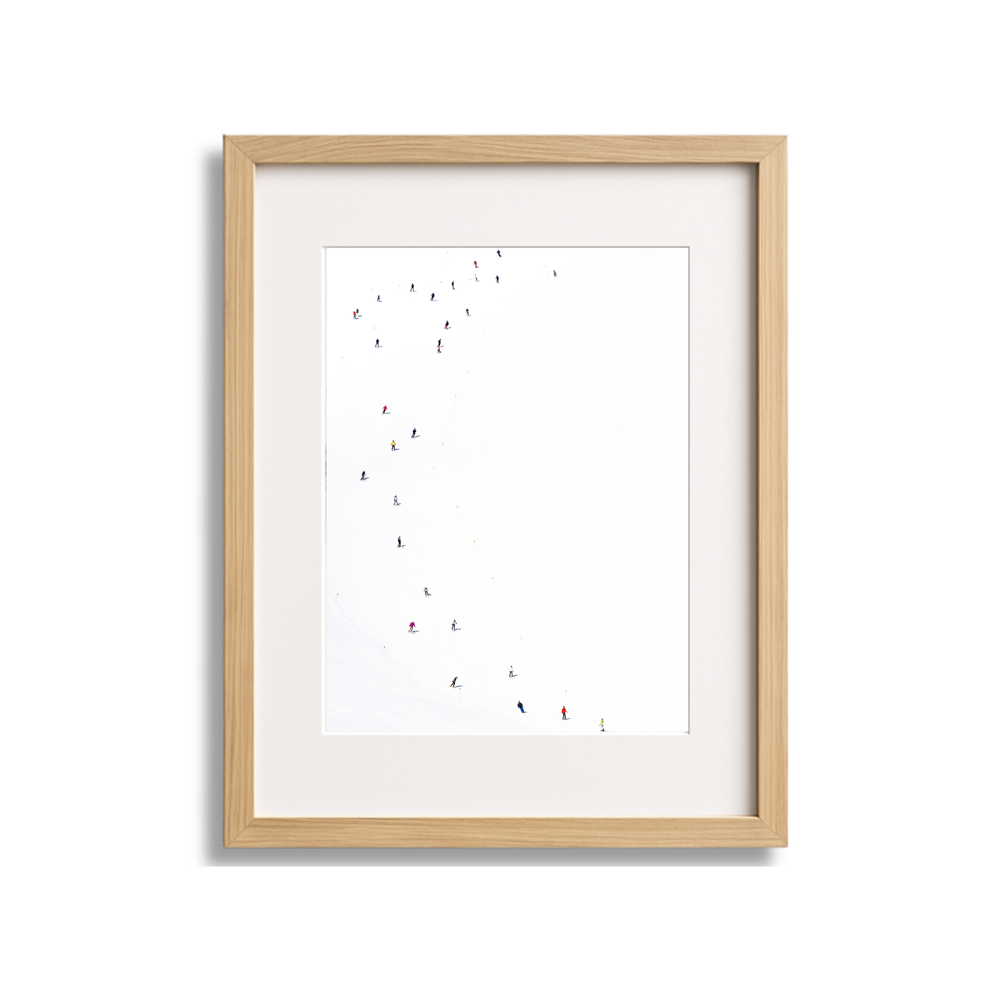An art print of numerous skiers on a snow-covered slope, viewed from above, in a wooden frame.