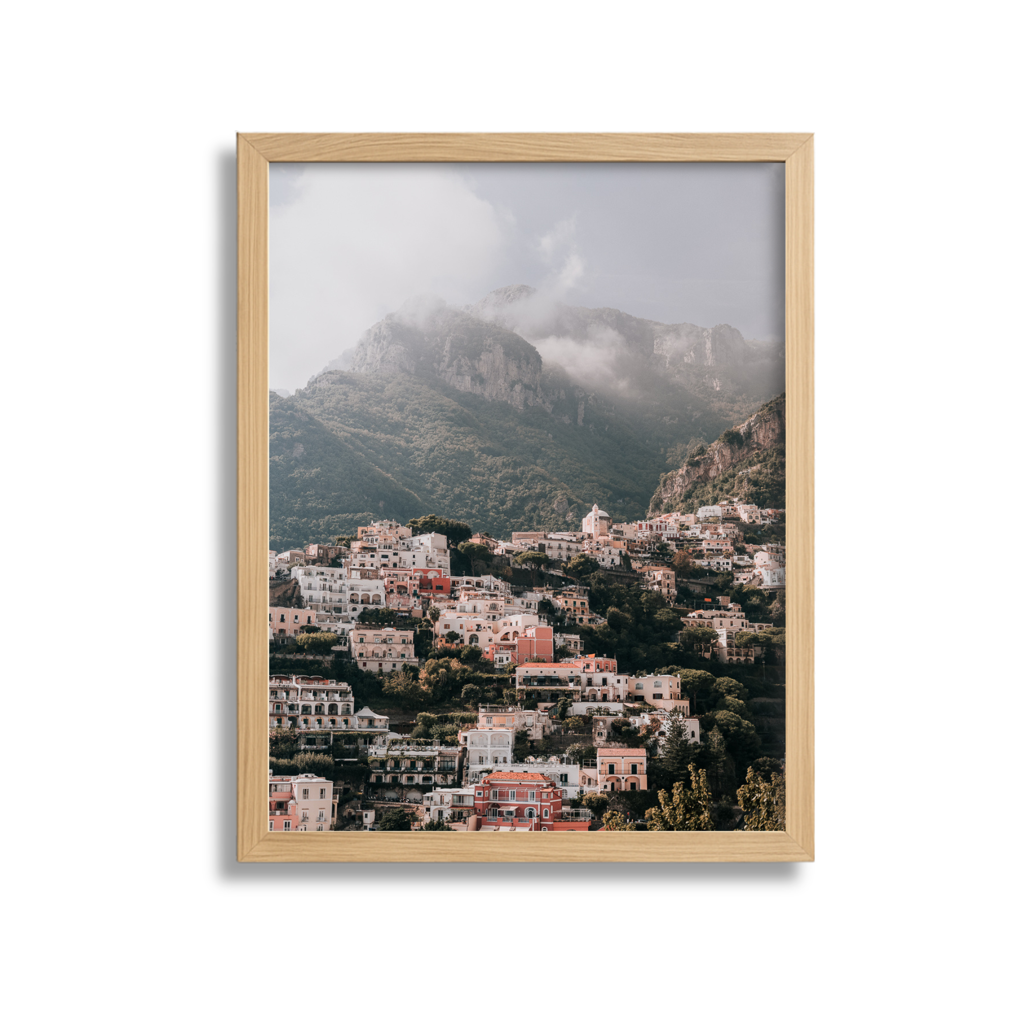 	
A large framed fine art photography print scenic view of Positano Italy with mountains and cloudy sky in the background with a wood frame.