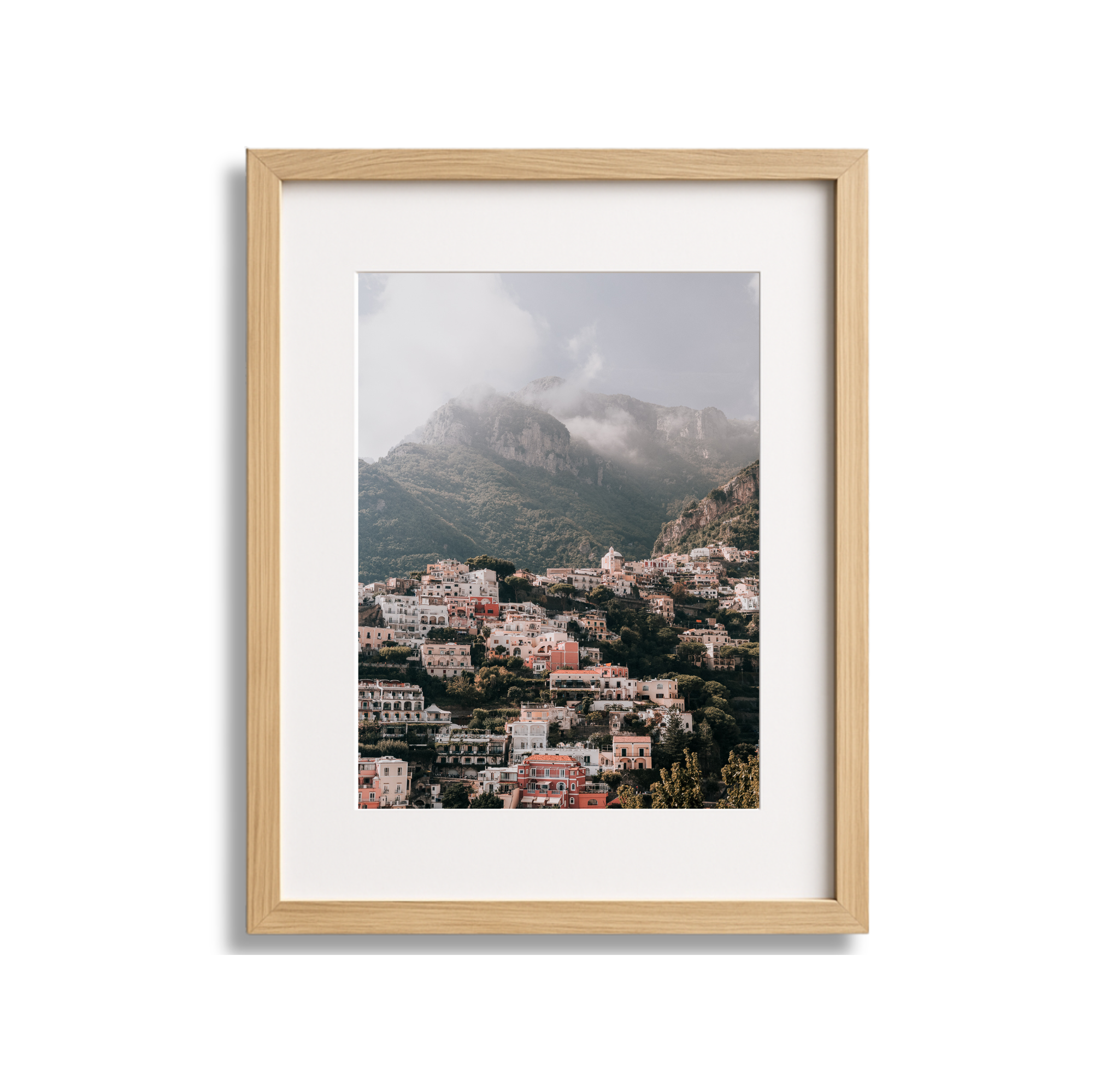 	
A large framed fine art photography print scenic view of Positano Italy with mountains and cloudy sky in the background with a wood frame.
