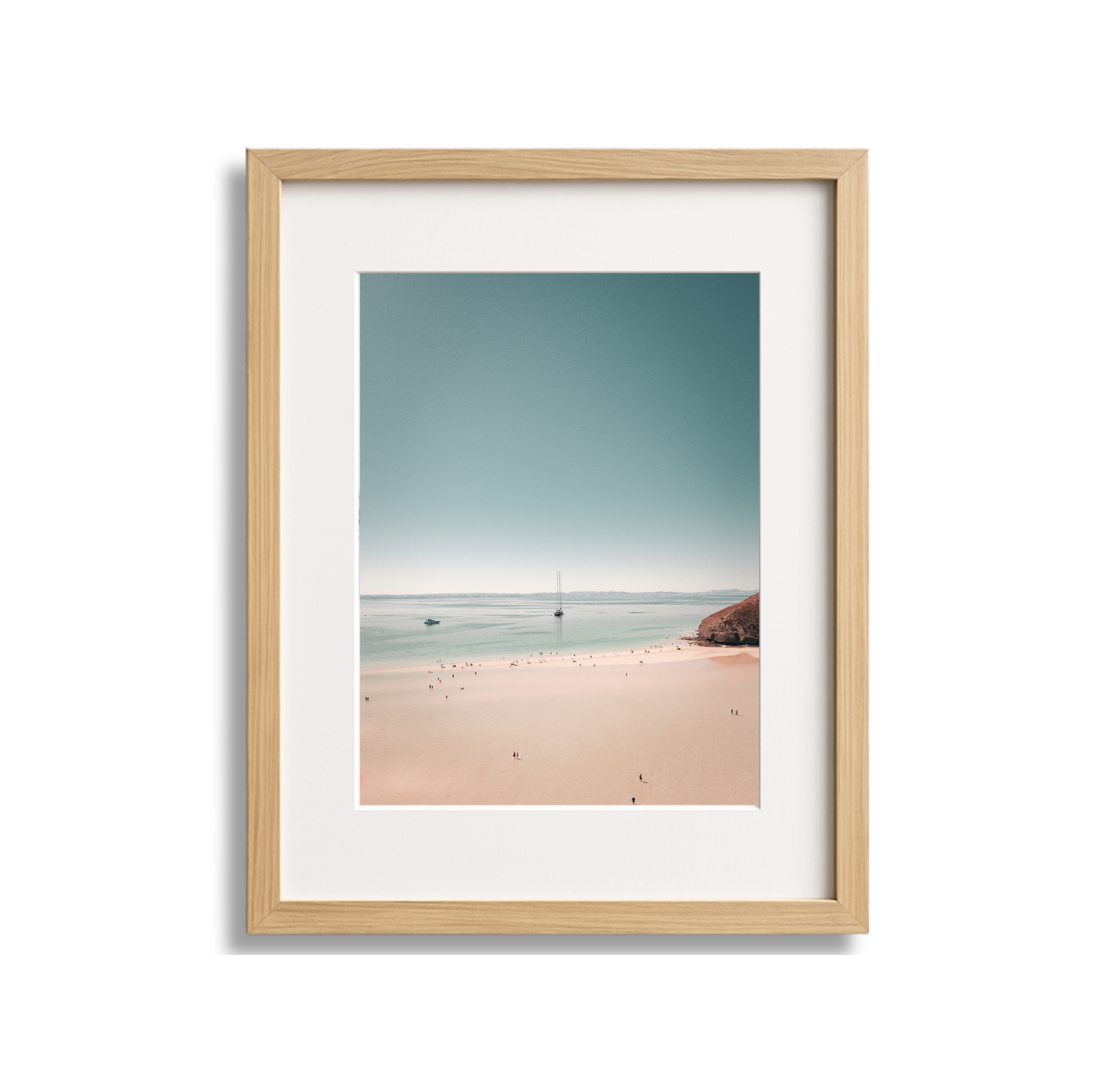 Framed watercolor painting of a beach scene with sand, water, a boat, and a sailboat on the horizon.