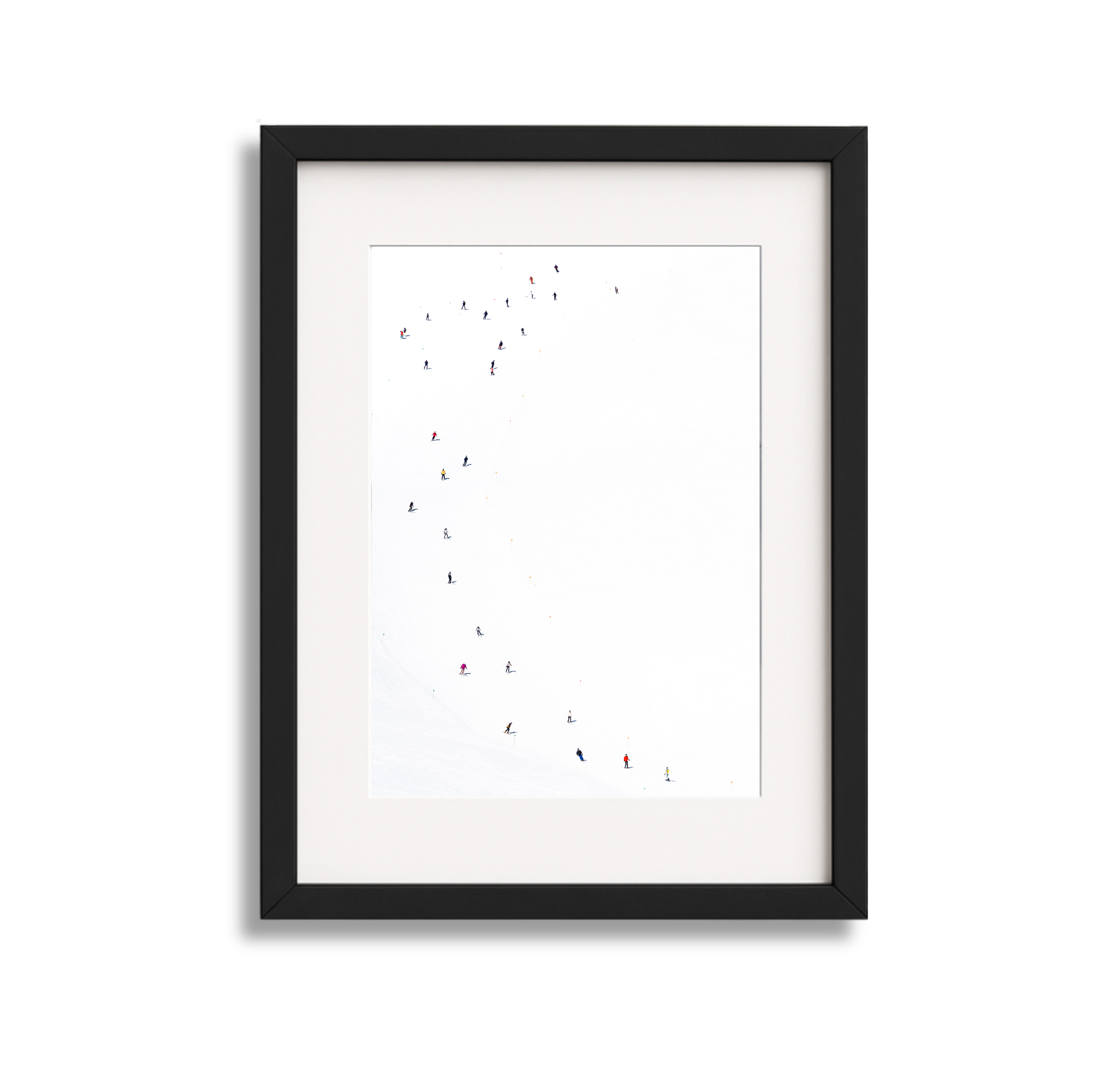 Framed photograph of people skiing on a snowy slope with a plain white background