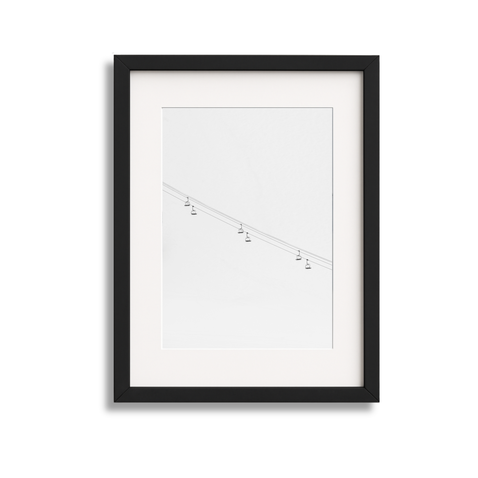Black picture frame containing a minimalistic line drawing of cable cars on a power line.