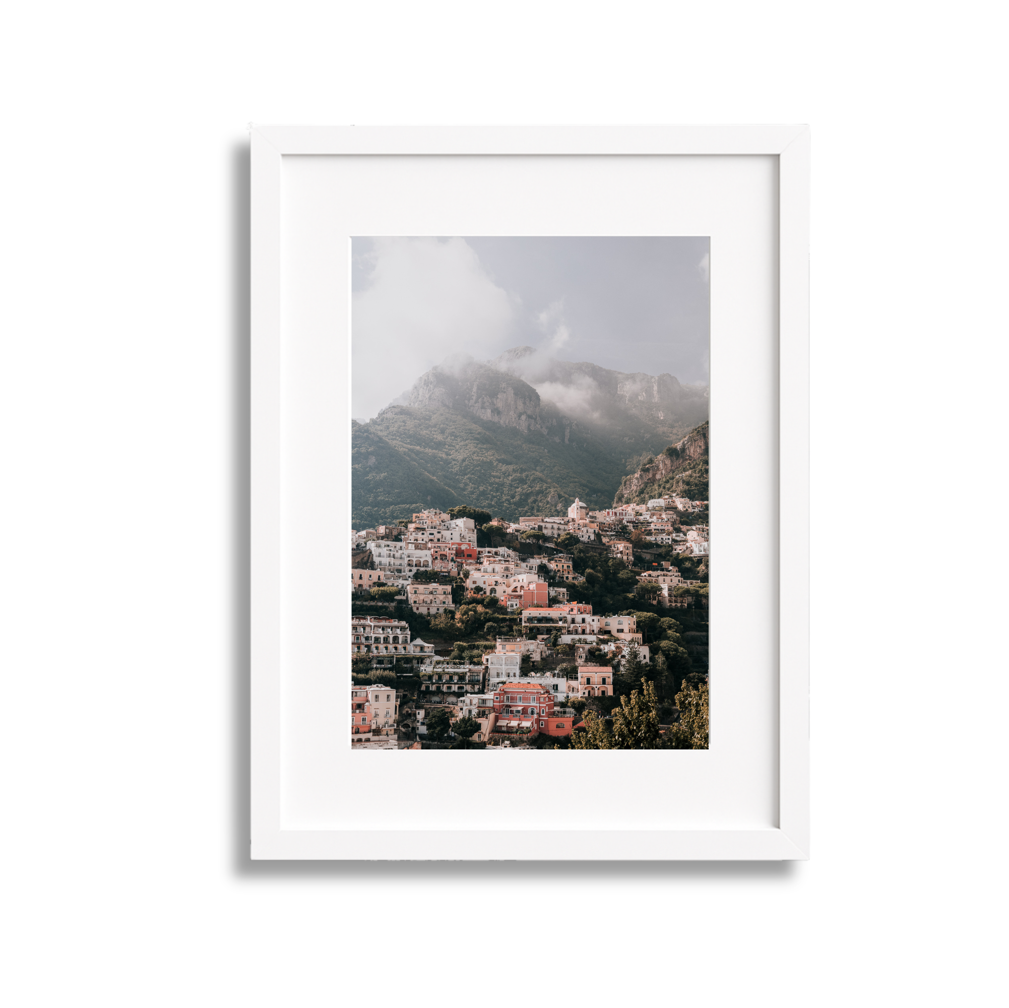 	
A large framed fine art photography print scenic view of Positano Italy, with mountains and cloudy sky in the background with a white frame.