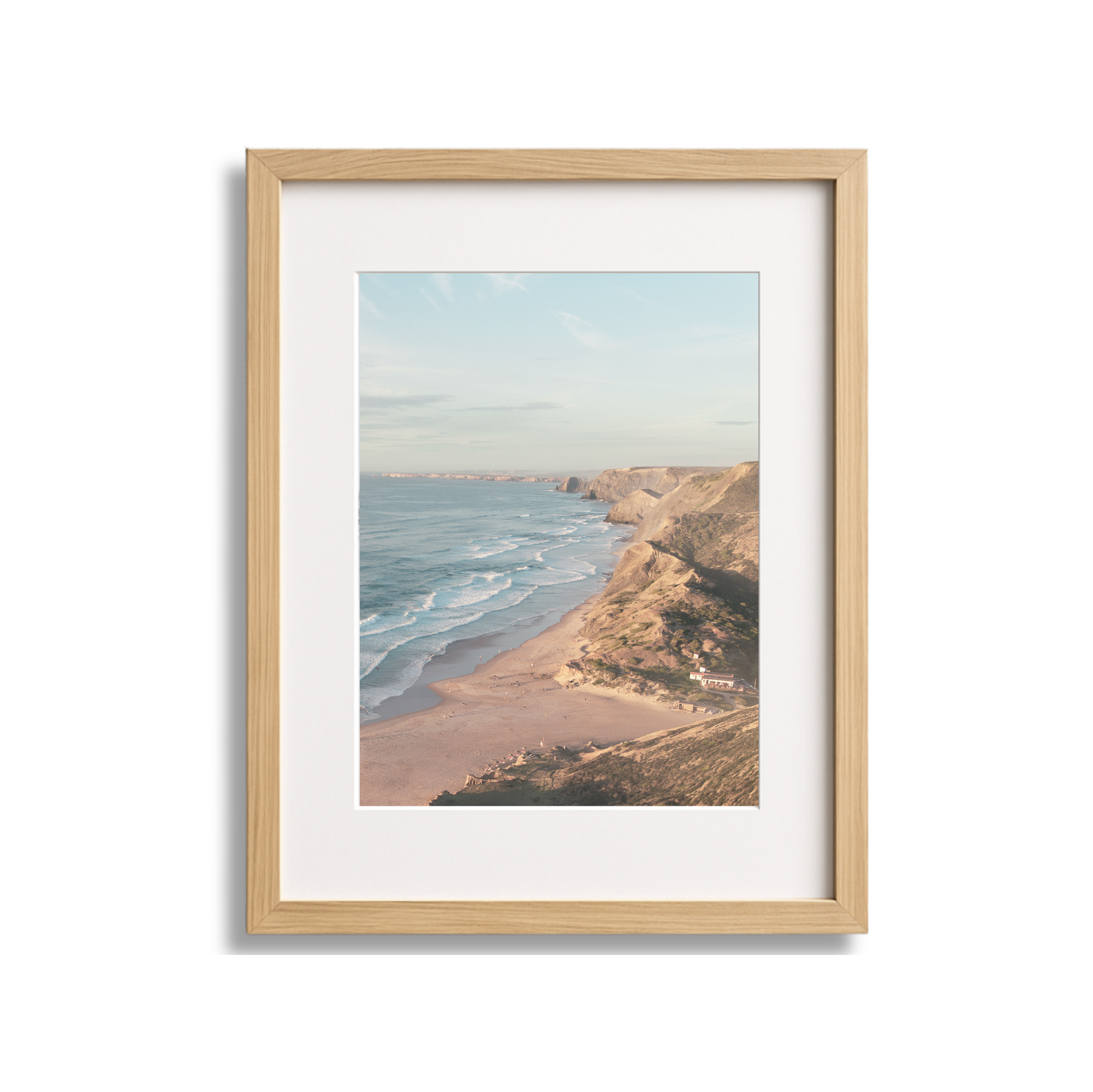 Framed aerial photograph of a coastal beach with cliffs and ocean waves.