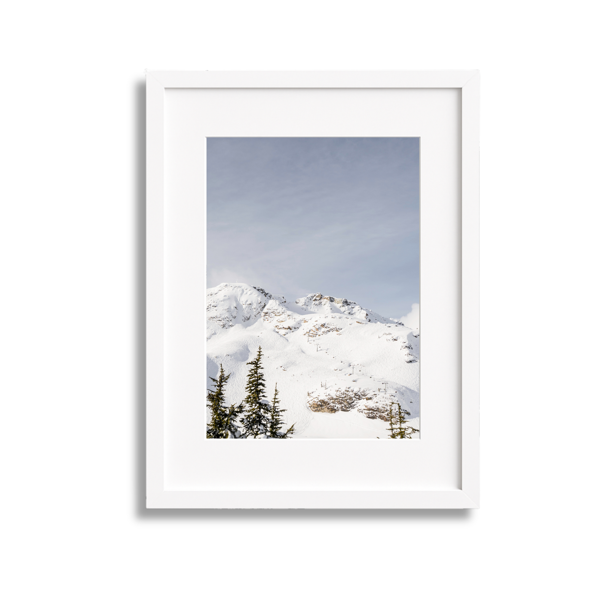 Snow-covered mountain landscape with evergreen trees in the foreground and a partly cloudy sky.