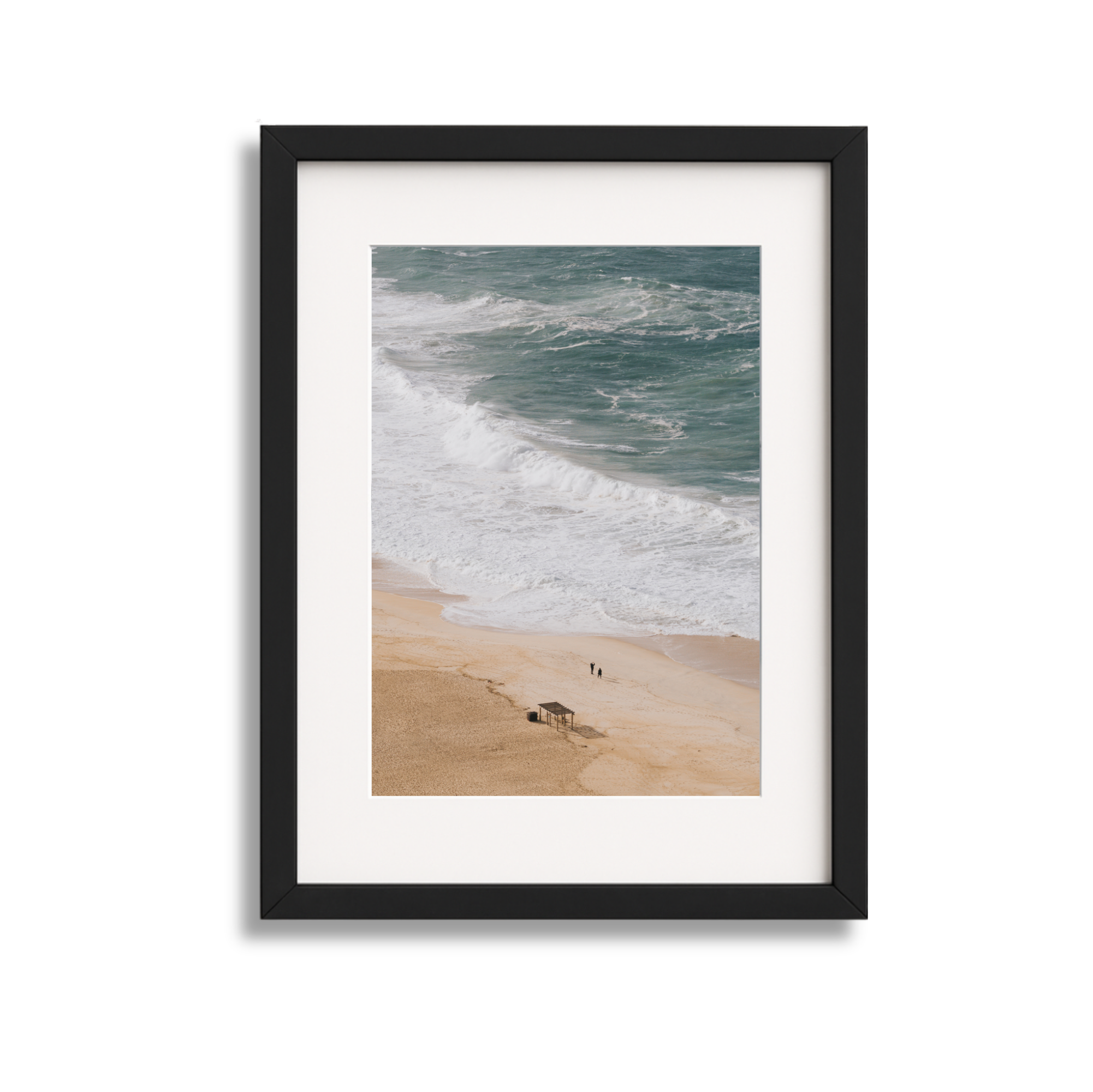 Framed photo of a beach with sandy shore, waves, and two people walking along the water's edge.