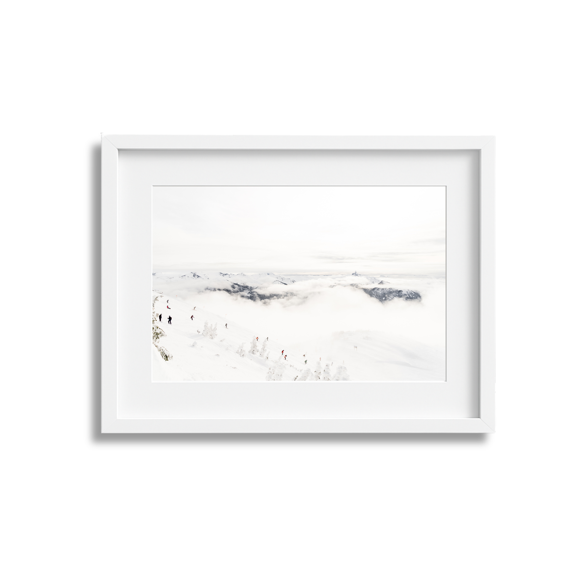 Snow-covered mountain landscape with skiers and cloudy sky in a white picture frame.