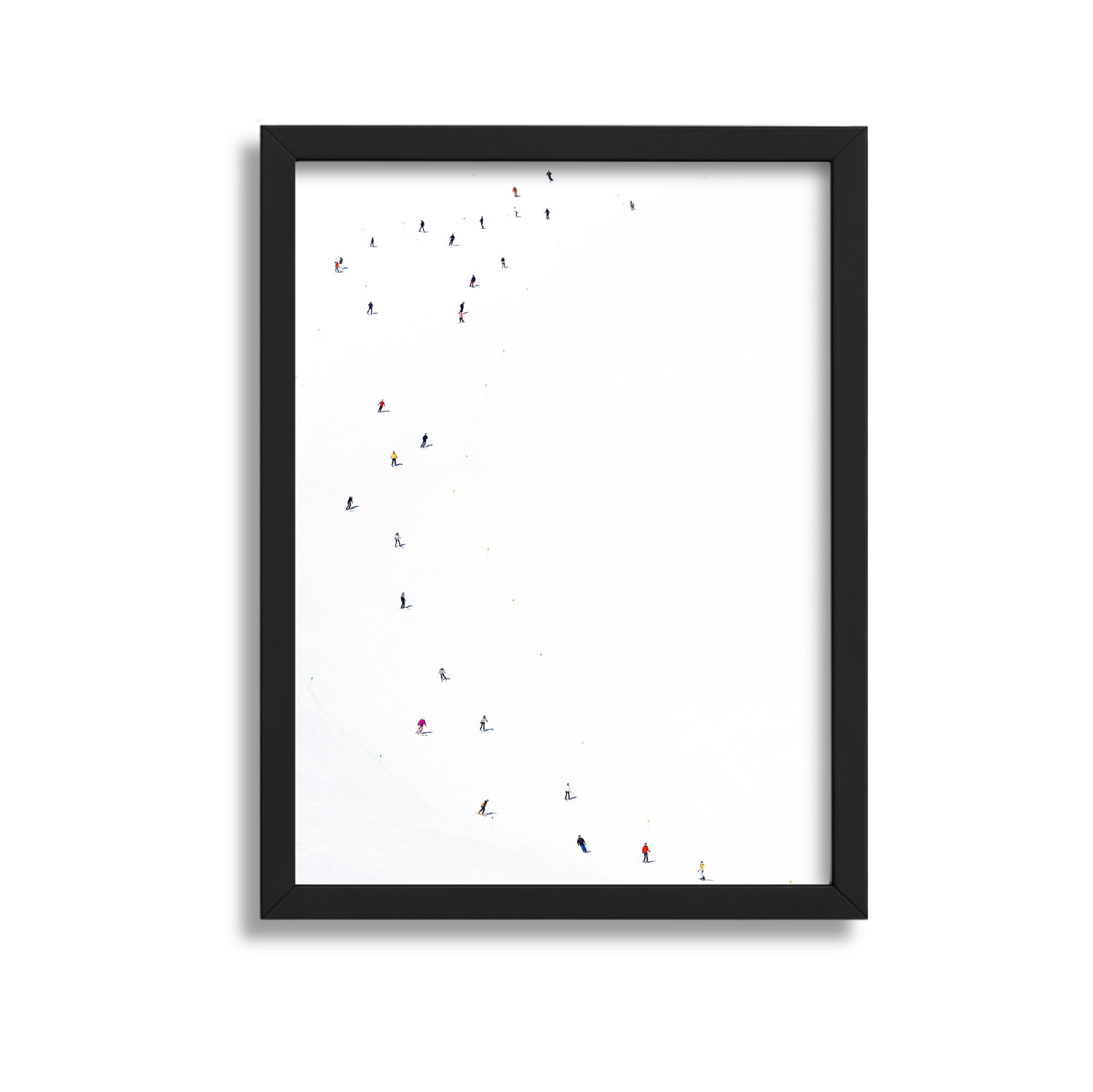 Framed photograph of skiers on a snow-covered slope, viewed from above.