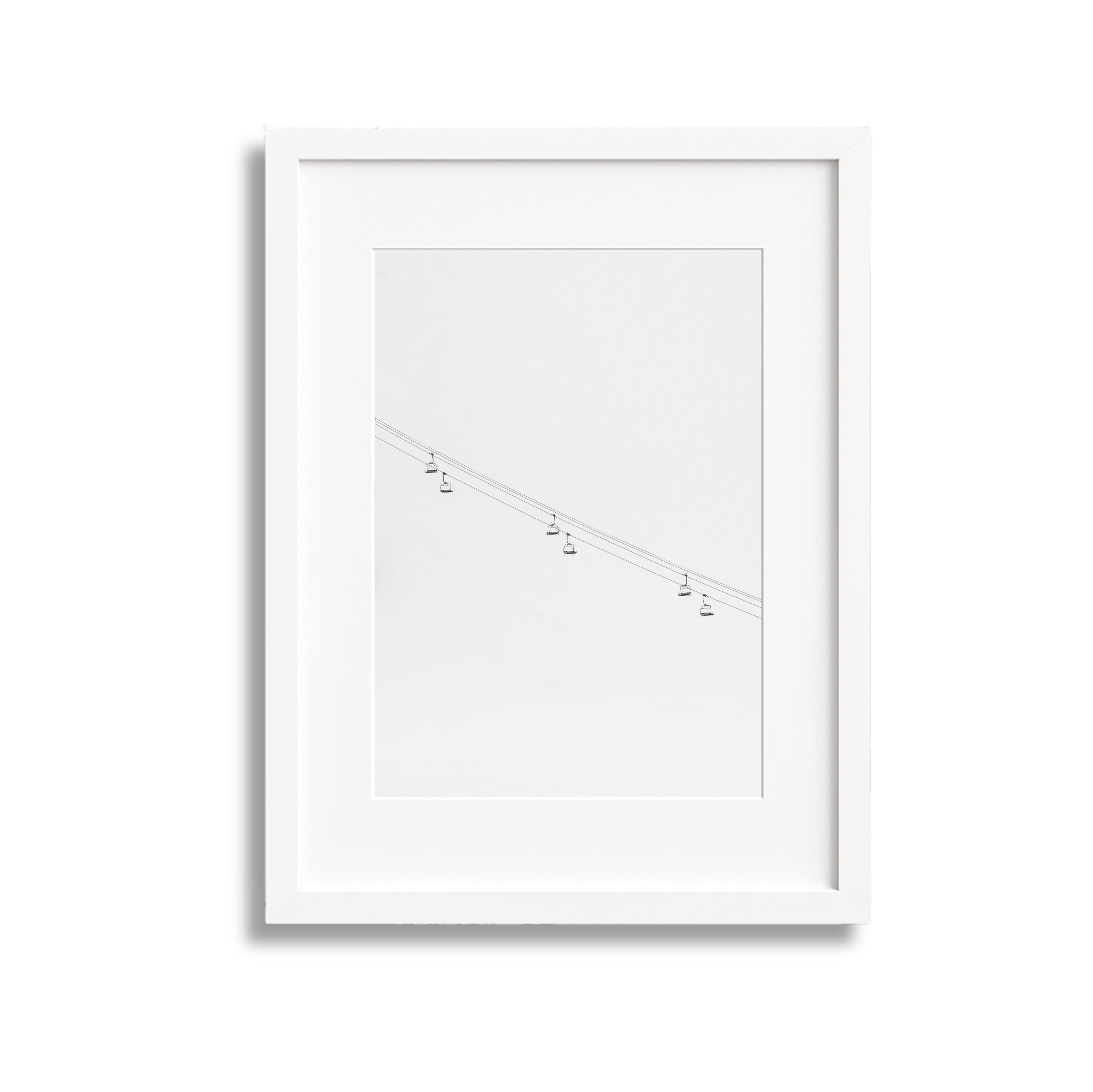 White picture frame containing a minimalist pencil sketch of a cable car system in the sky.