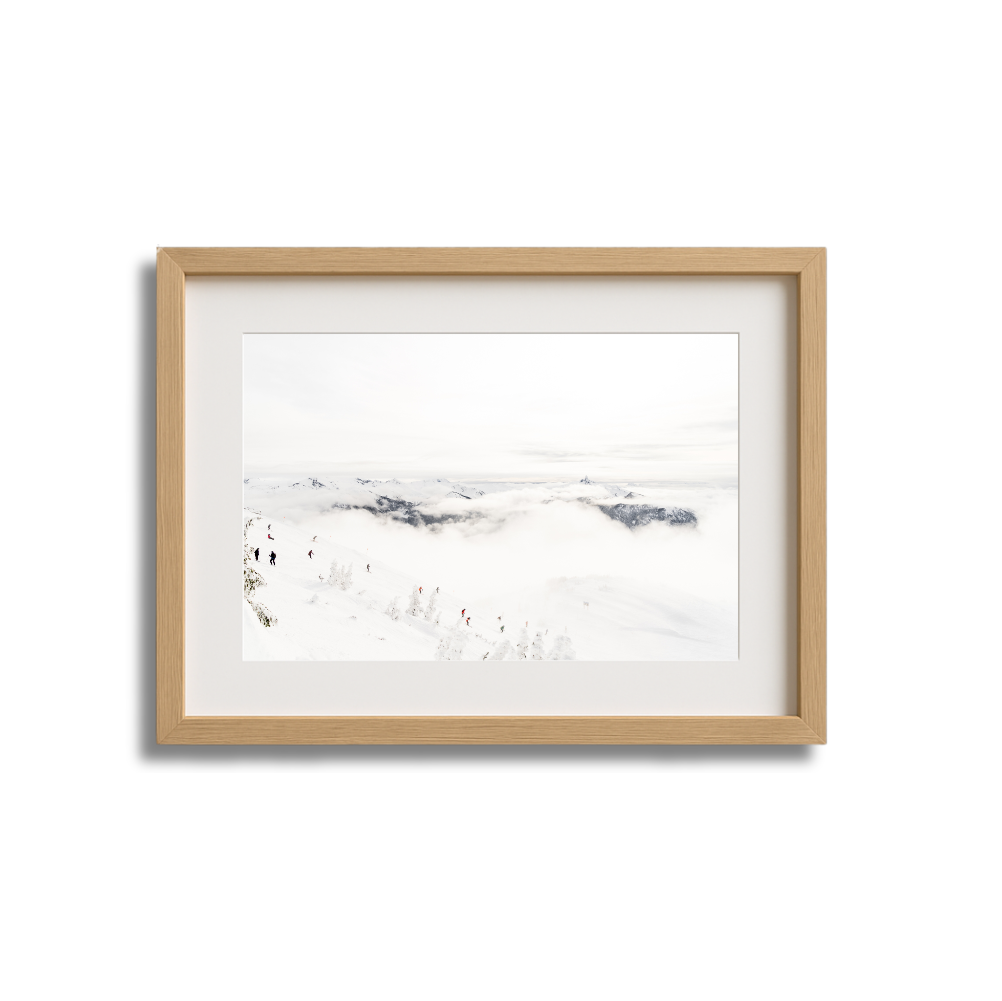A framed picture of snowy mountain landscape with hikers trekking through the snow, clouds, and distant mountain peaks.