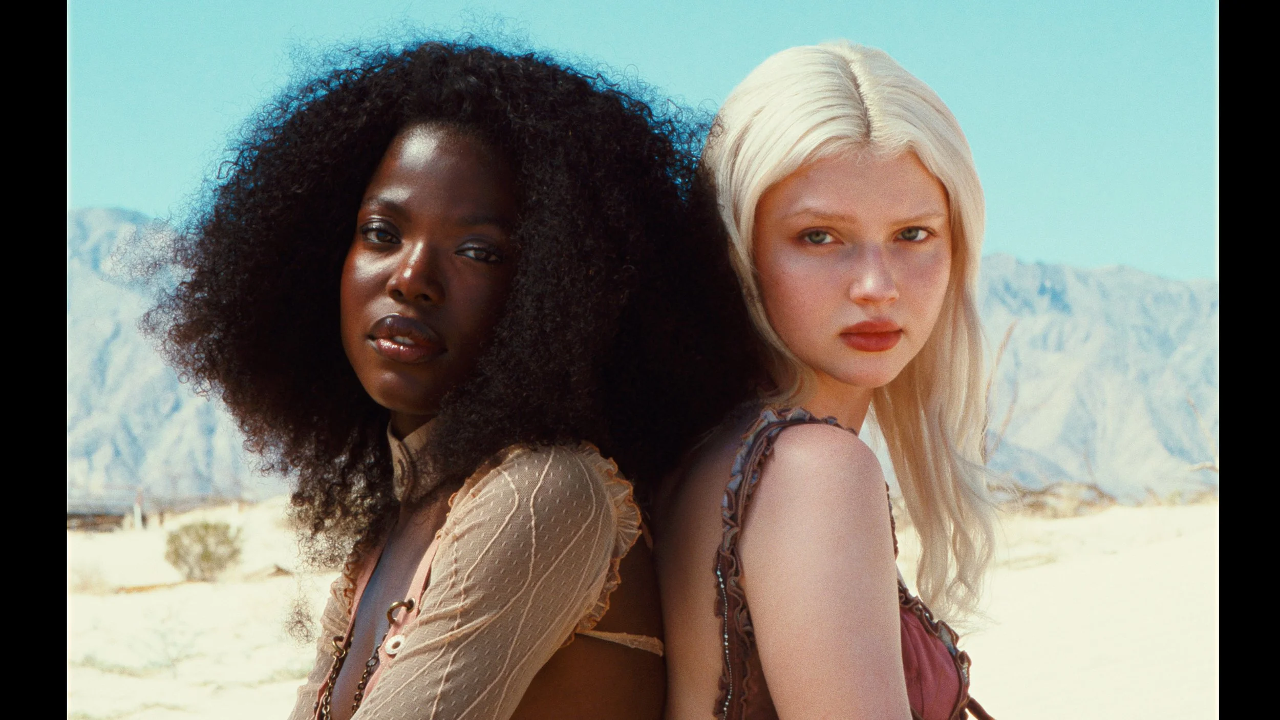 Fashion models against desert backdrop, soft cinematic lighting