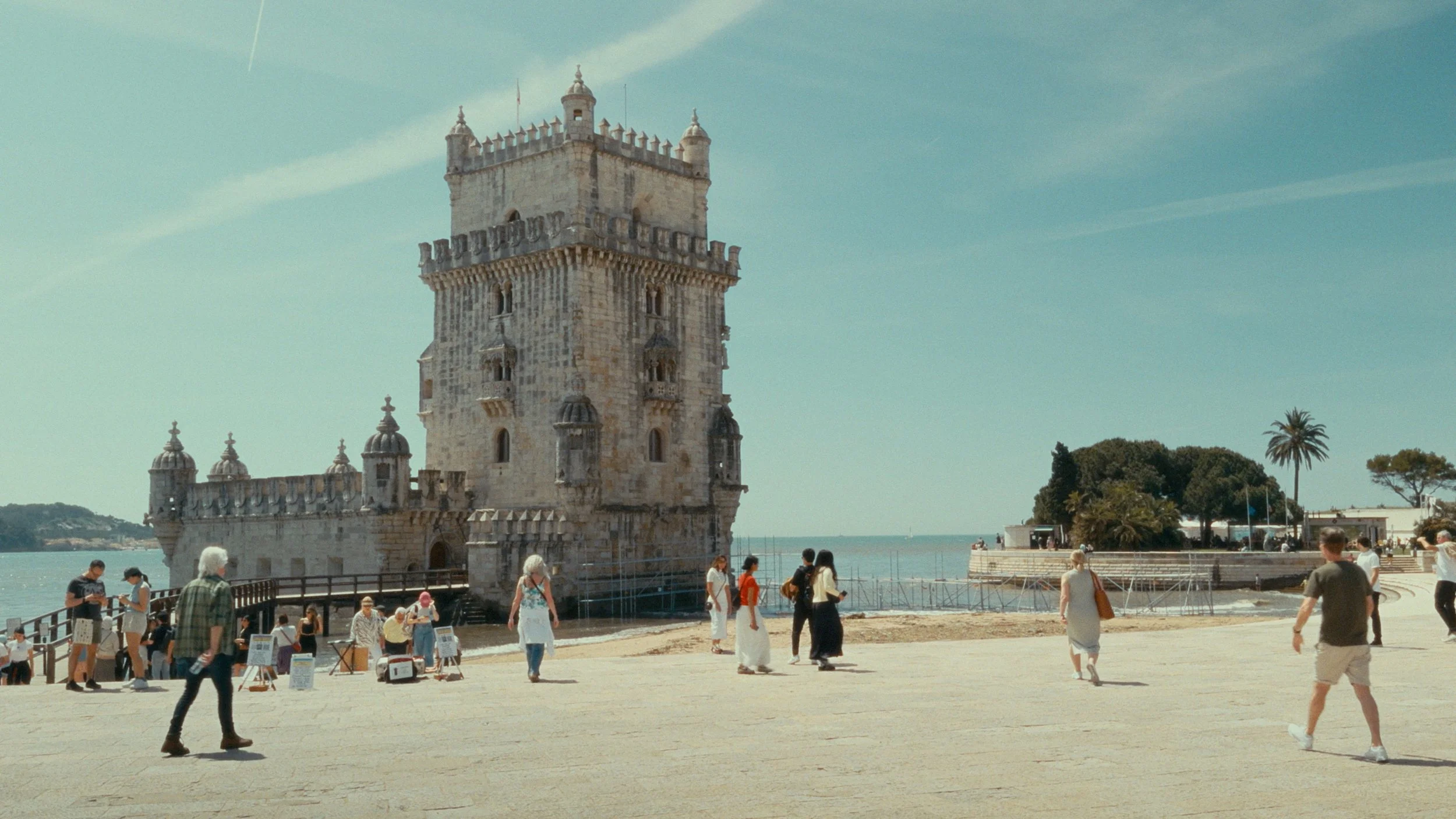 A crowd of tourists around a medieval castle at the beach, vintage film stock color grading