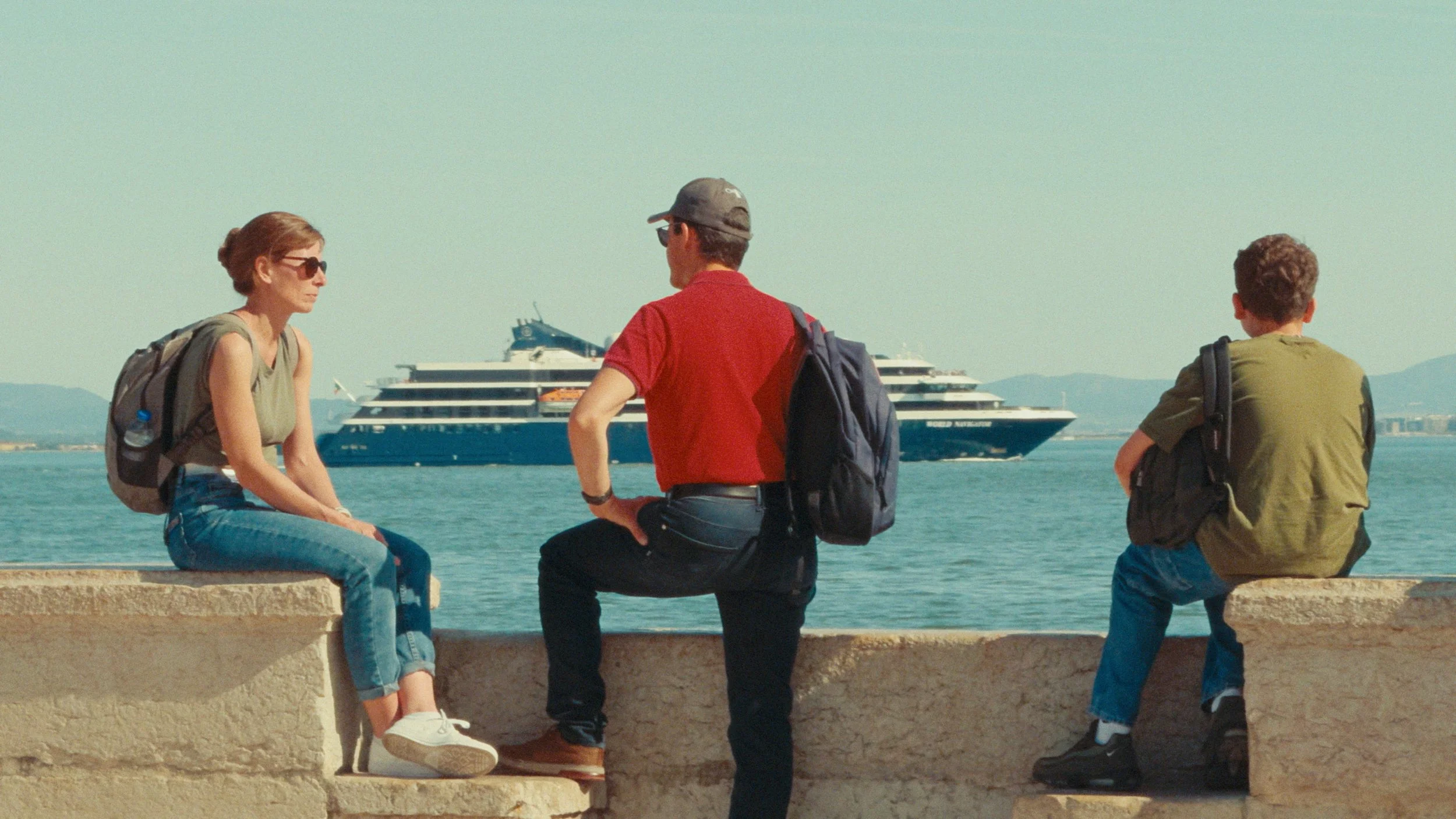 Man, woman, and son watch a ship at the harbor, colored like 35mm Kodak film