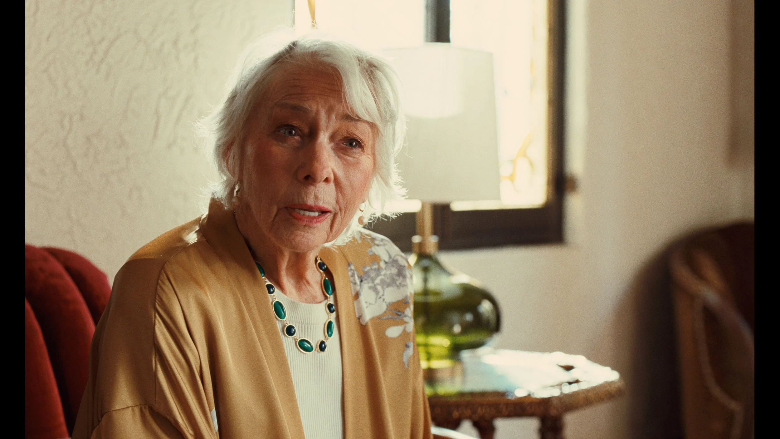 Old lady sitting near window with cinematic film print LUT
