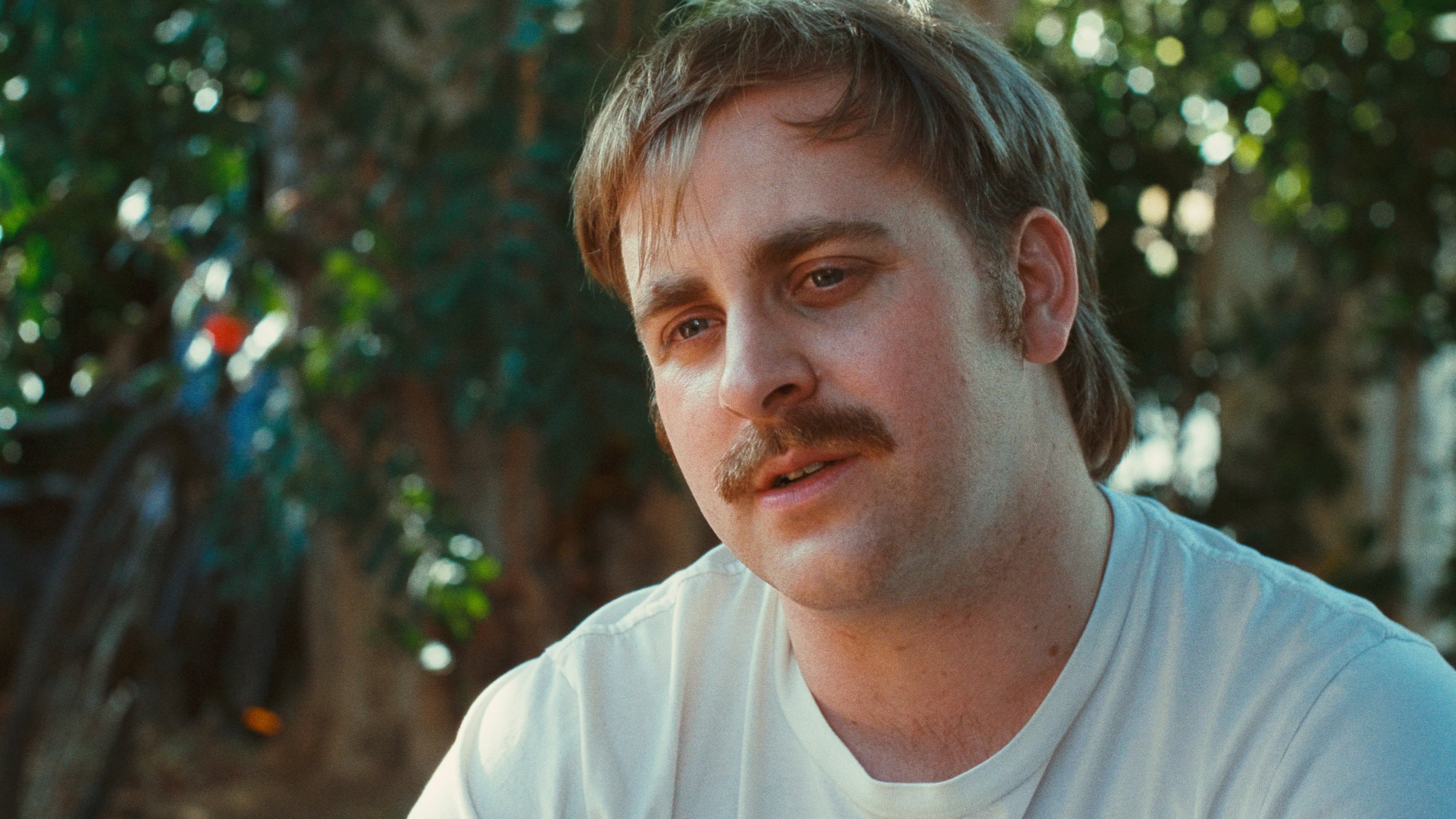 Medium close up on man surrounded by foliage
