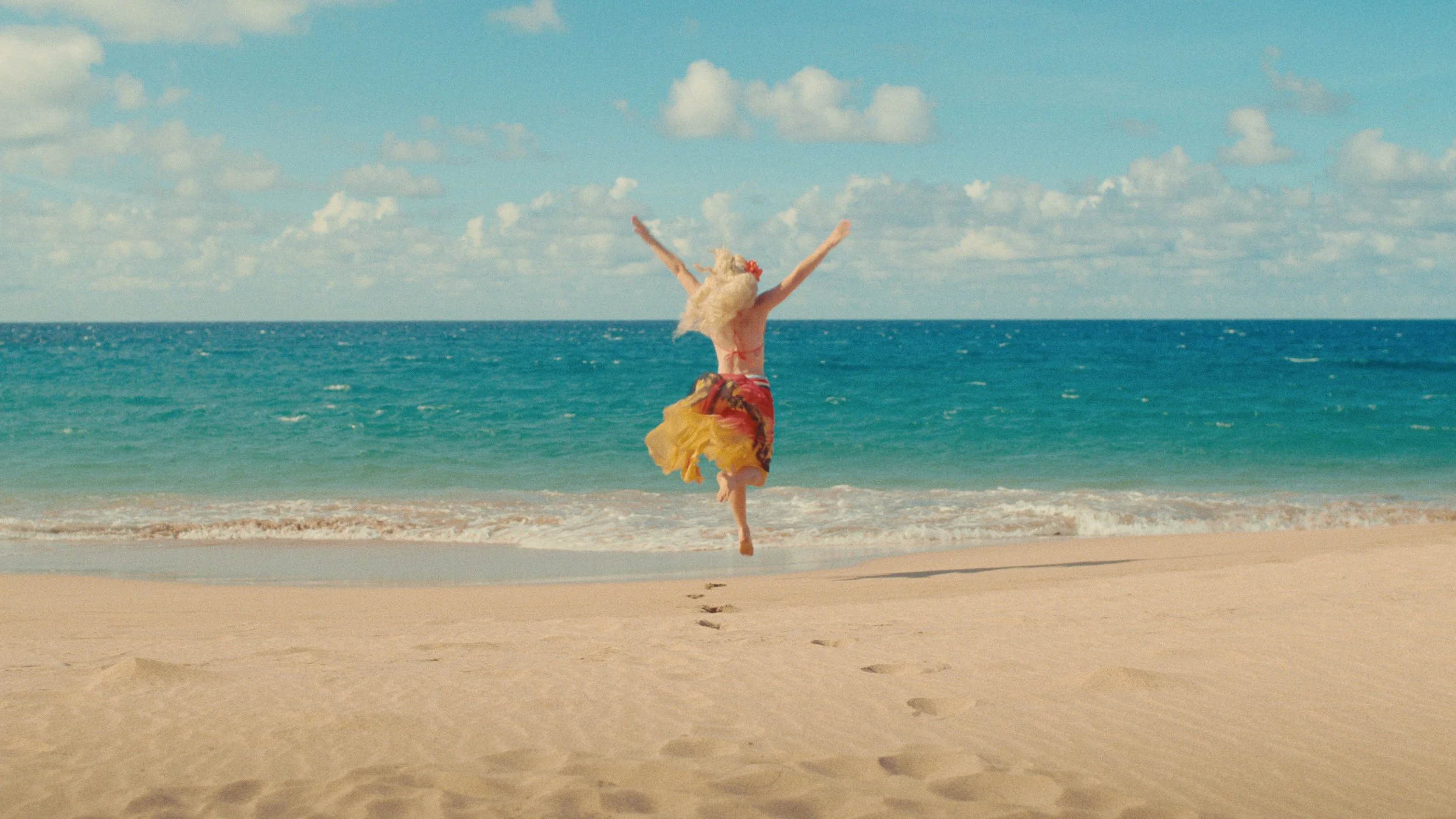 Woman running towards ocean at tropical beach
