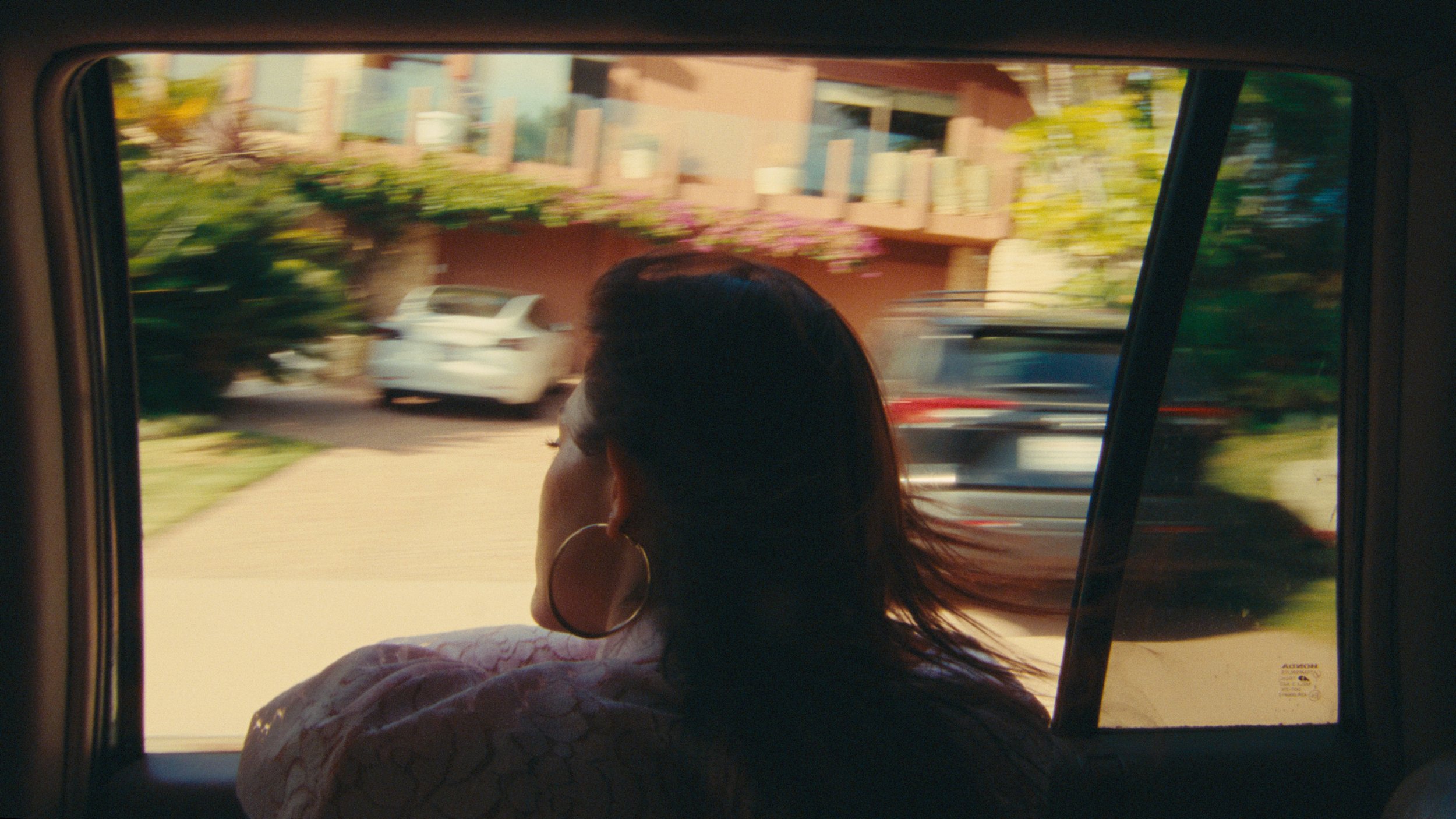 Woman in car with hair blowing in the wind color graded with 35mm film look