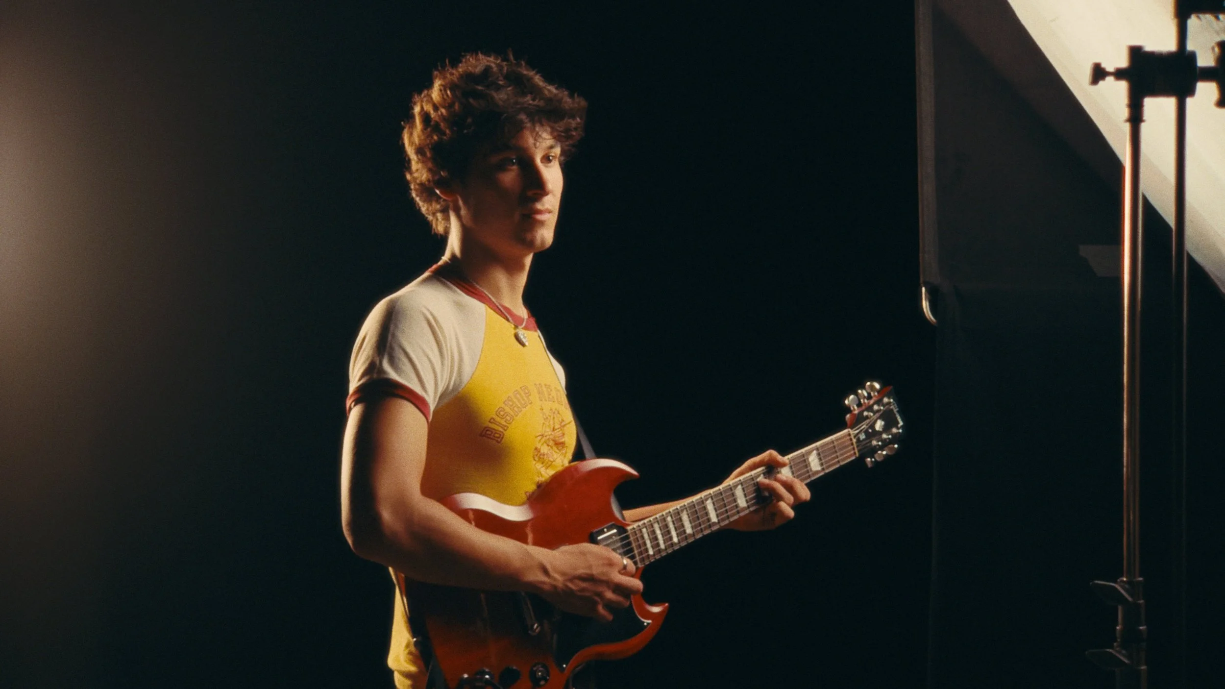 Man playing red guitar in cinematic lighting