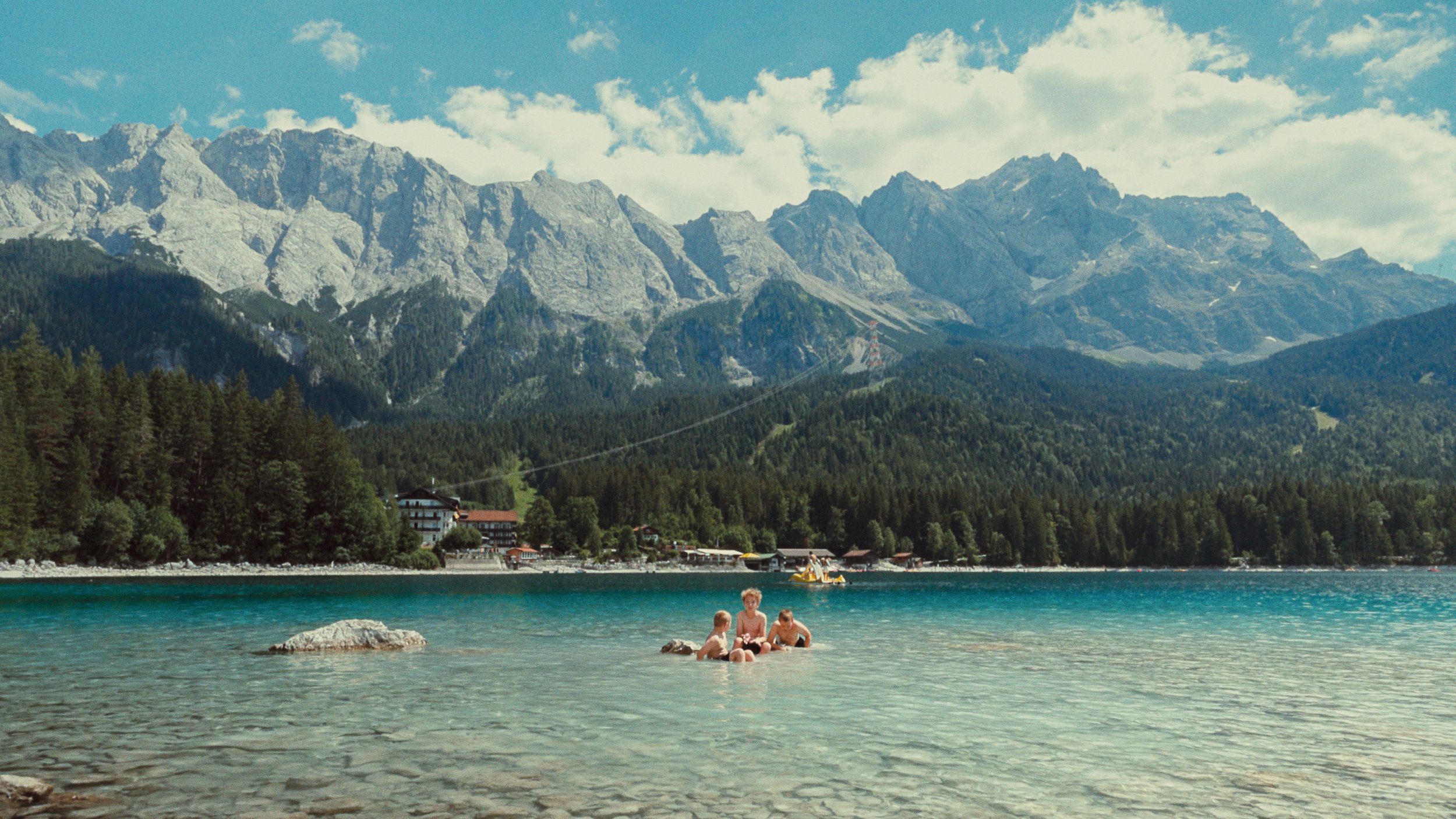 Children playing in a clear mountain lake in Germany, color graded with kodak ektachrome film emulation