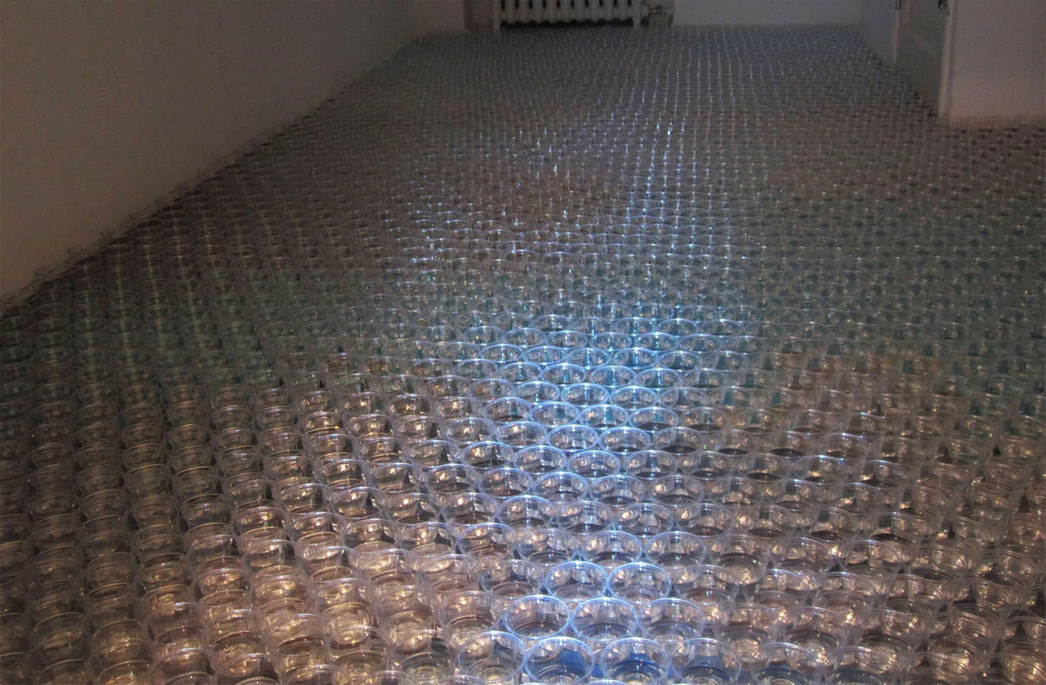 MÖRTVIK V,  2012   Muovilasit, vesi, valokuvat, projisointi meren pinnasta Mörtvikistä, Pyhtää   Plastic cups, water, photographs, projection of the surface of the sea filmed in Mörtvik, Pyhtää, Finland