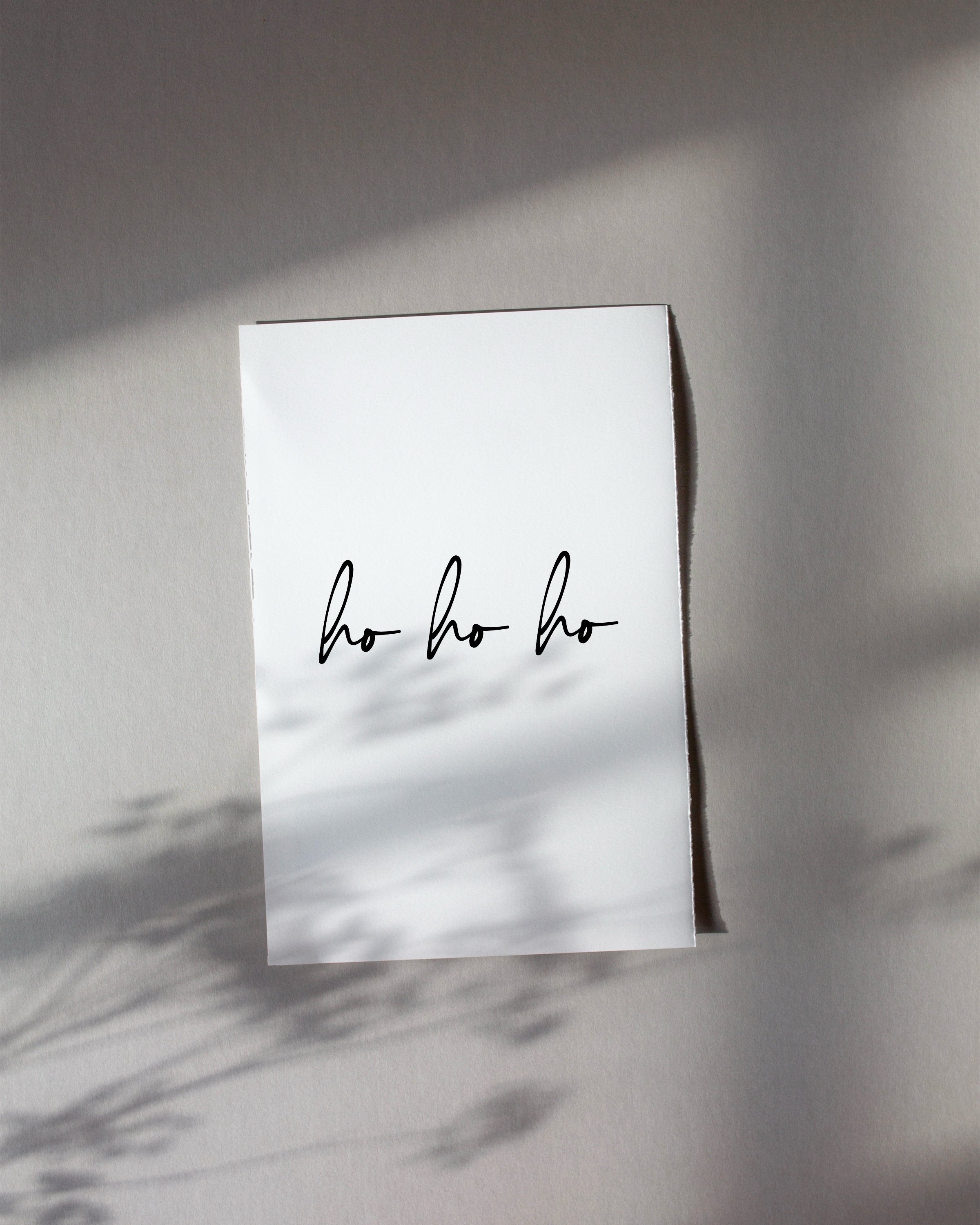 Minimalist “Ho Ho Ho” art print in black script on a white background, perfect for holiday decor.