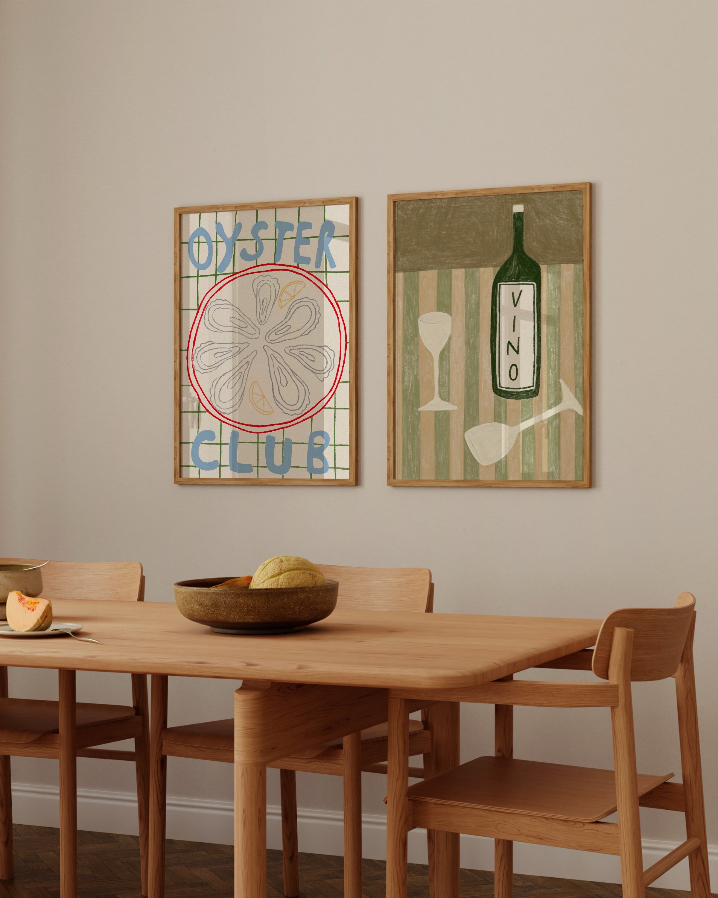 Two framed art prints: one featuring a colorful oyster illustration with the text ‘Oyster Club’ and another showcasing a green wine bottle labeled ‘Vino’ with glasses on a striped background.