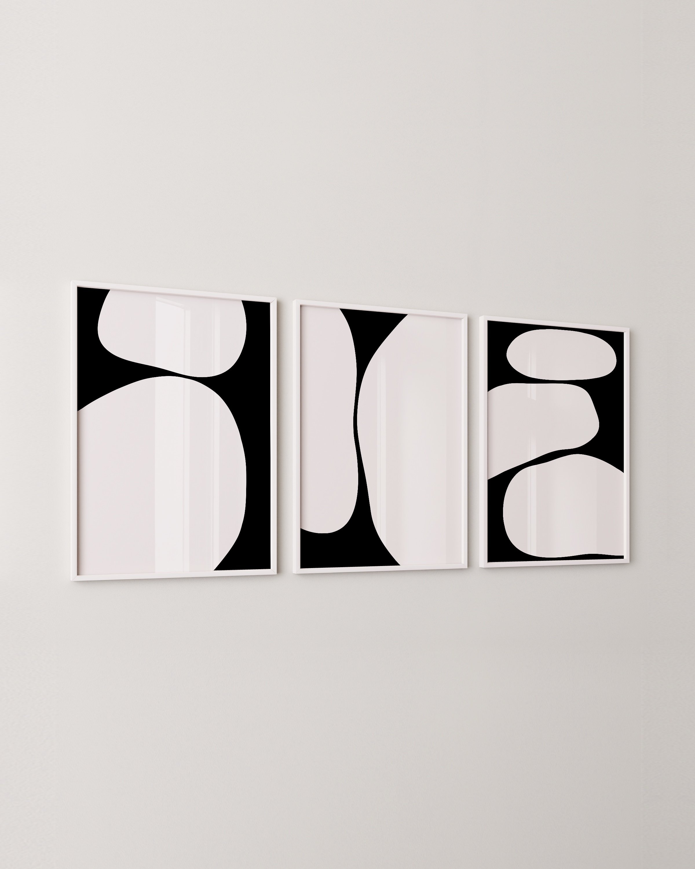 A set of three abstract black and white art prints featuring bold, minimalist shapes in a cohesive triptych design.