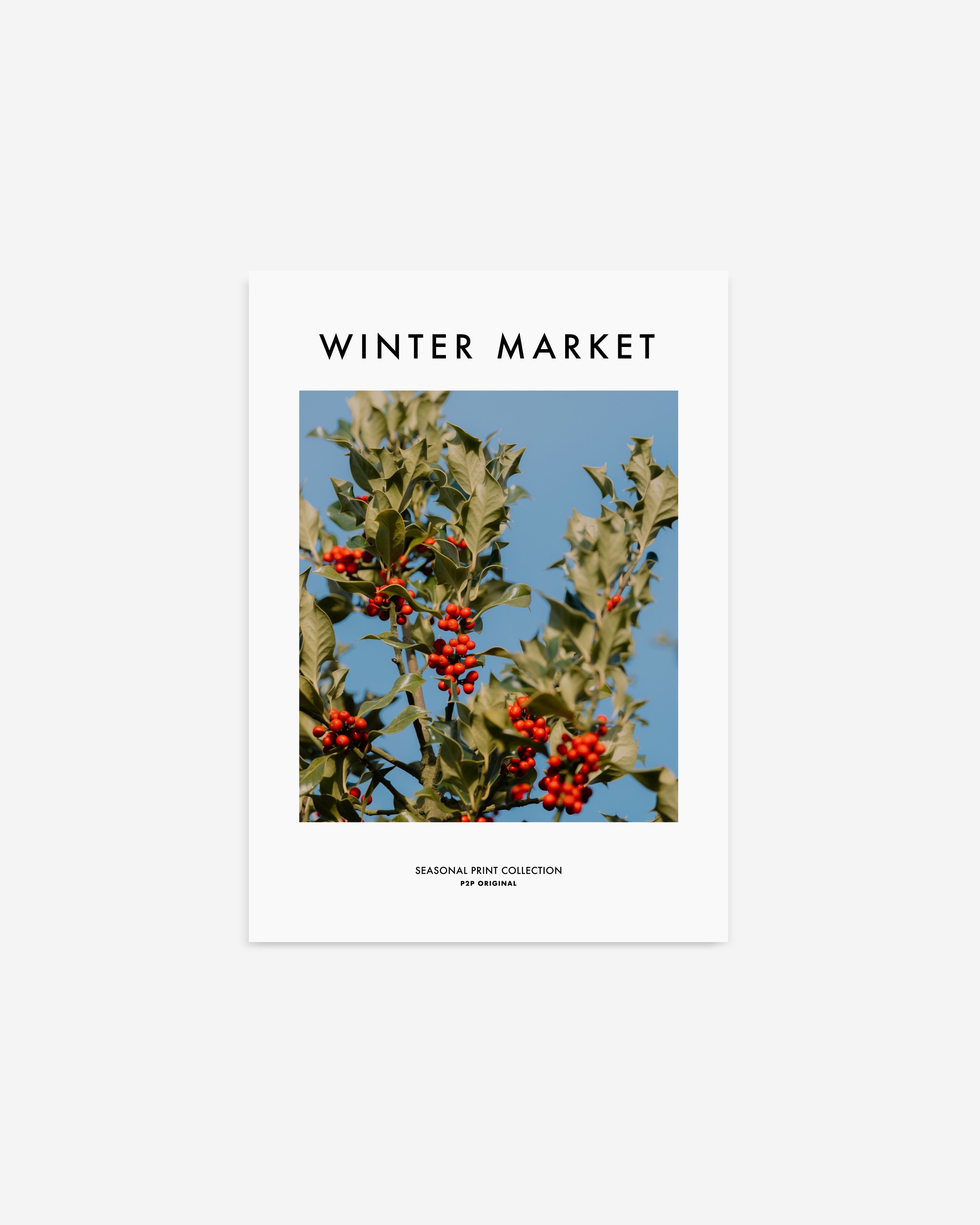 Vibrant photograph of red holly berries with green leaves set against a bright blue sky, perfect for festive holiday decor.