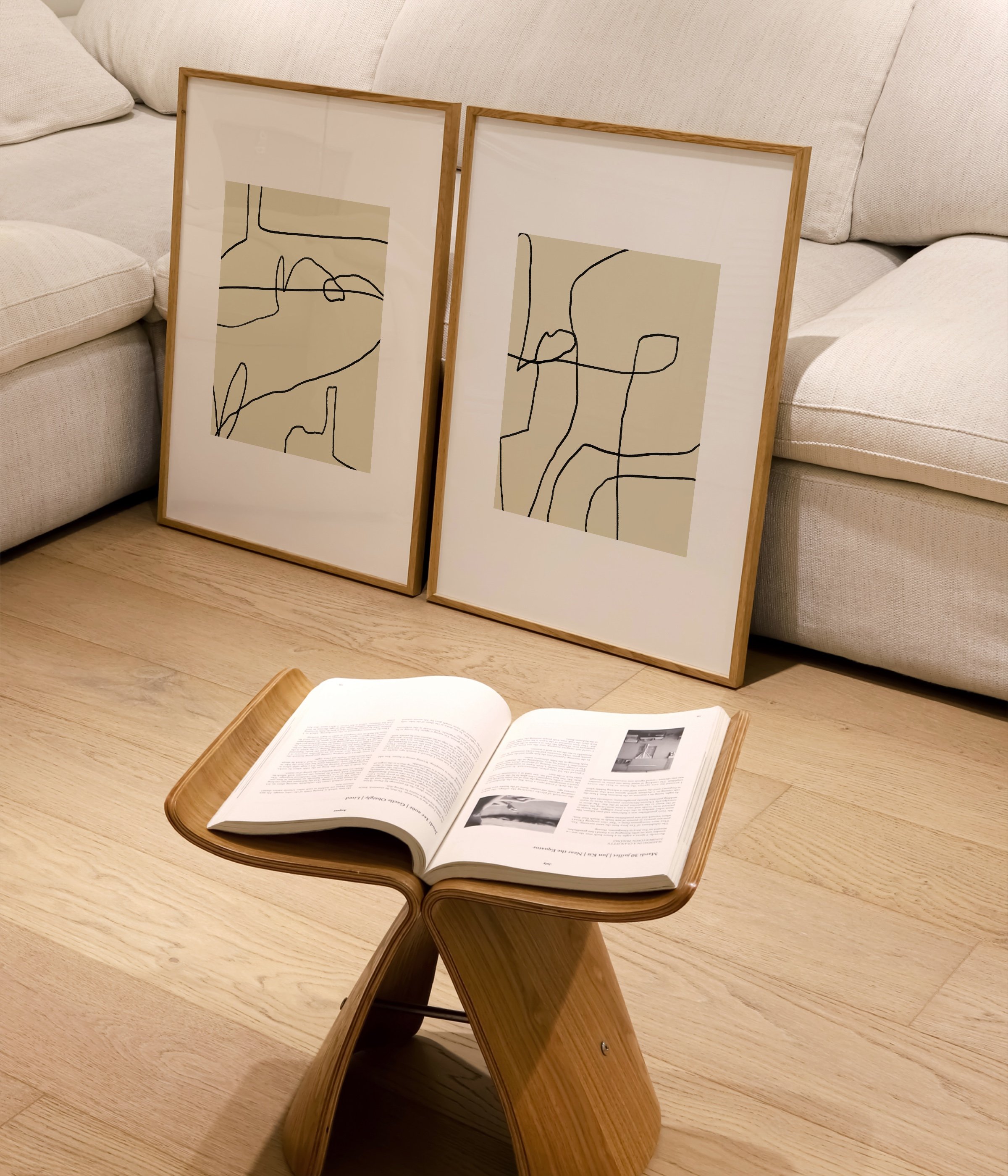 Set of two abstract line art prints in white frames, each featuring black continuous line designs over beige backgrounds with minimal, modern style.