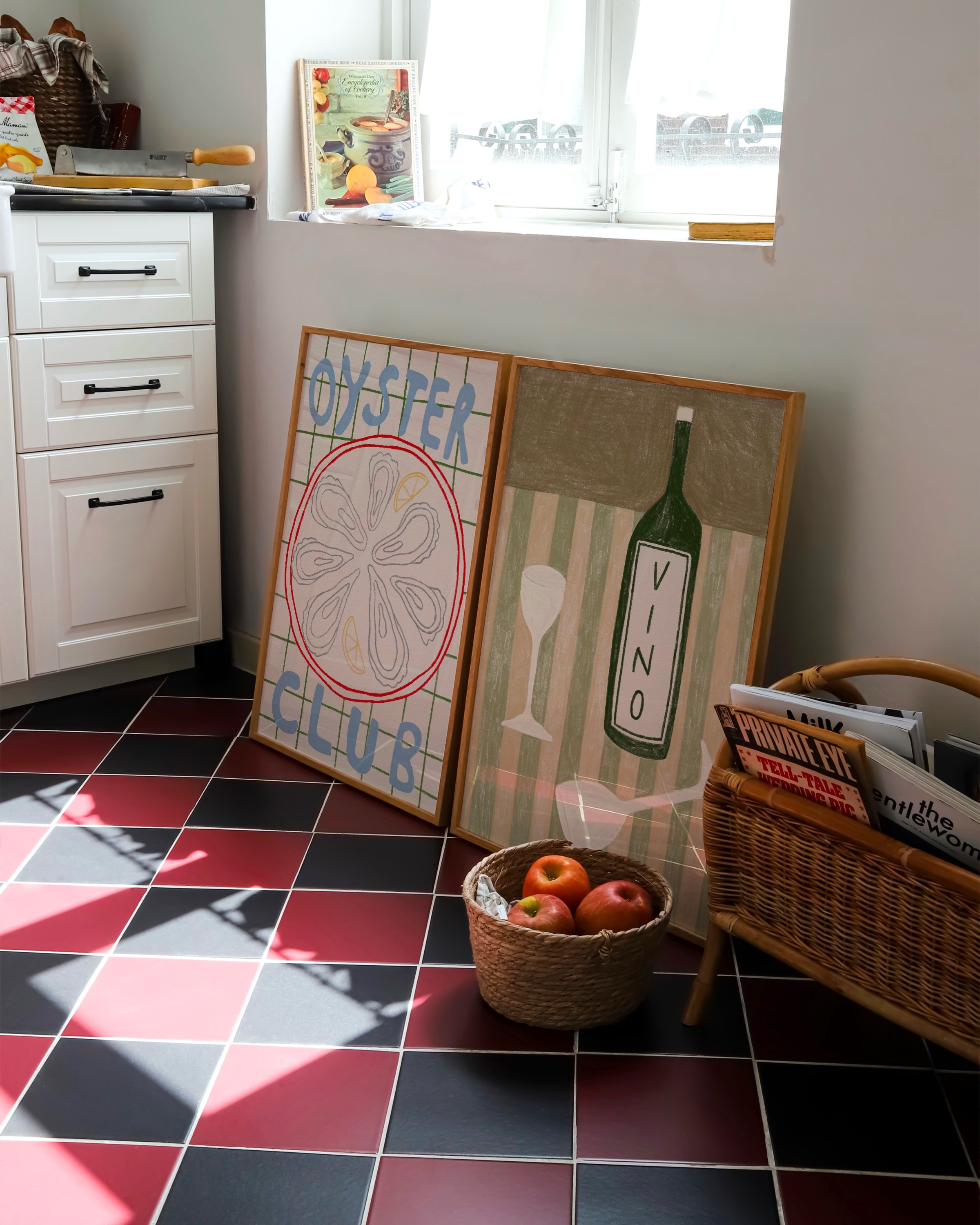 Two framed art prints: one featuring a colorful oyster illustration with the text ‘Oyster Club’ and another showcasing a green wine bottle labeled ‘Vino’ with glasses on a striped background.