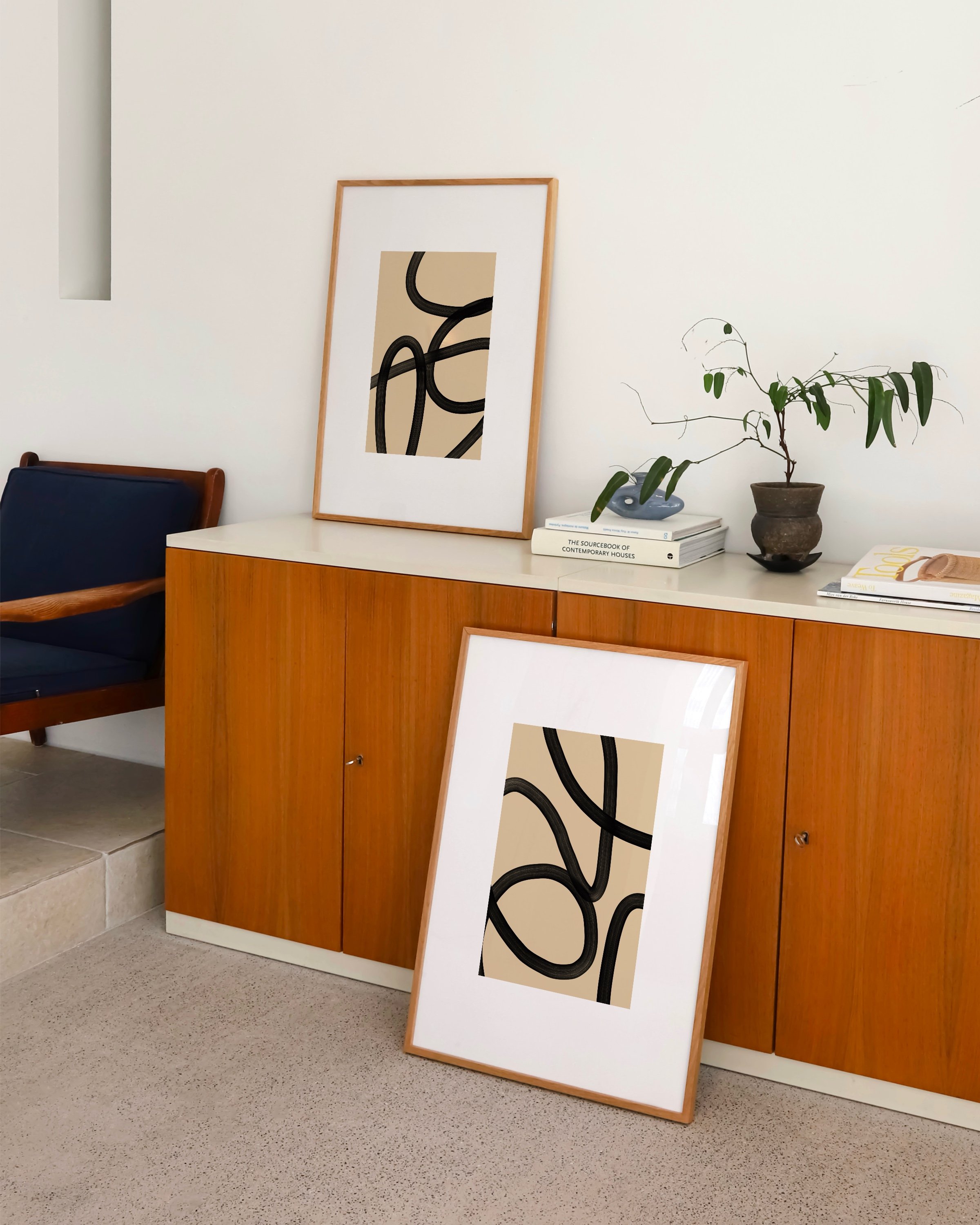 Set of two abstract black and beige line art prints featuring bold, flowing lines on a neutral background, ideal for modern and minimalist decor.