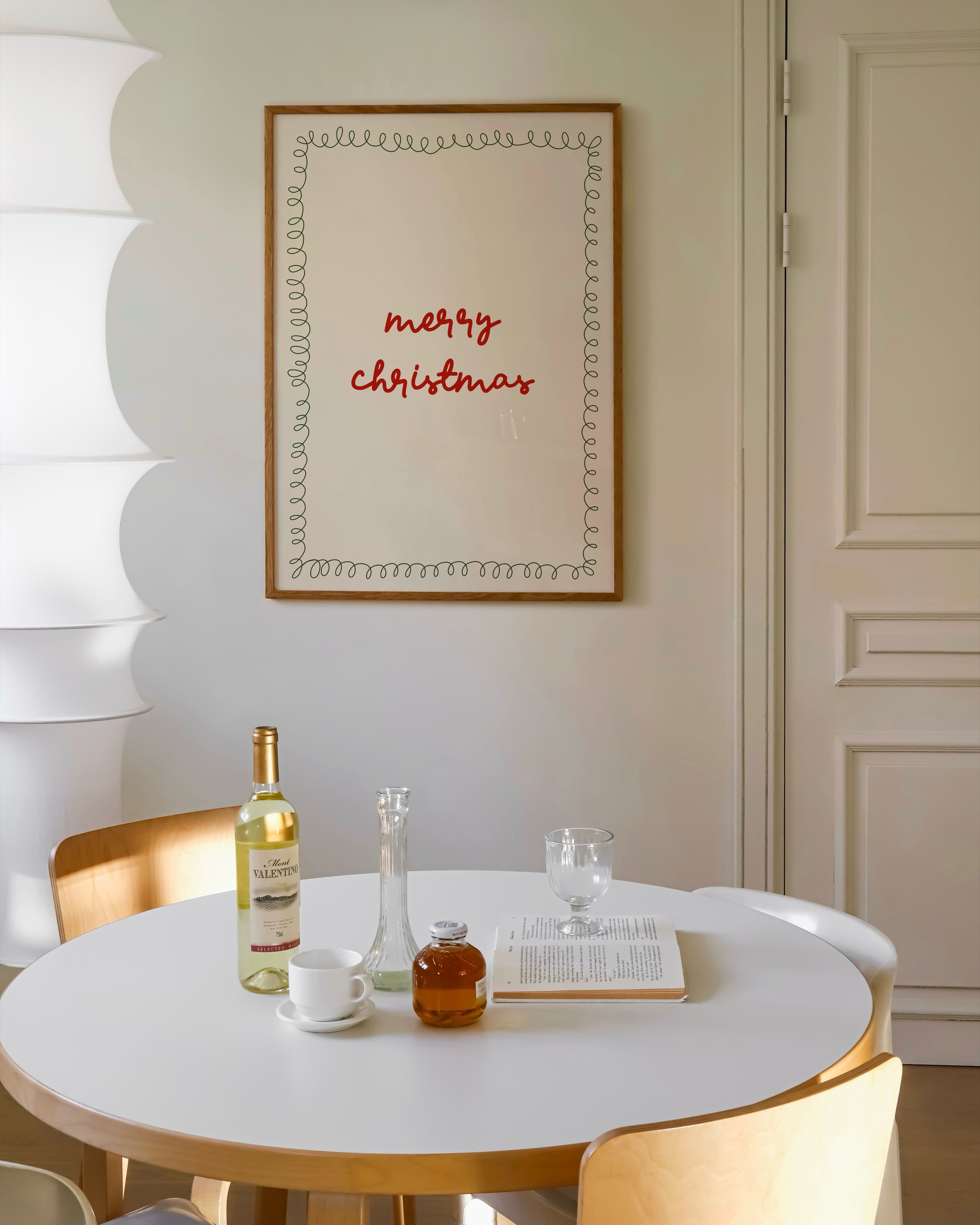 Minimalist Christmas printable art with red ‘Merry Christmas’ text in a handwritten style, framed by a green squiggle border on a beige background.