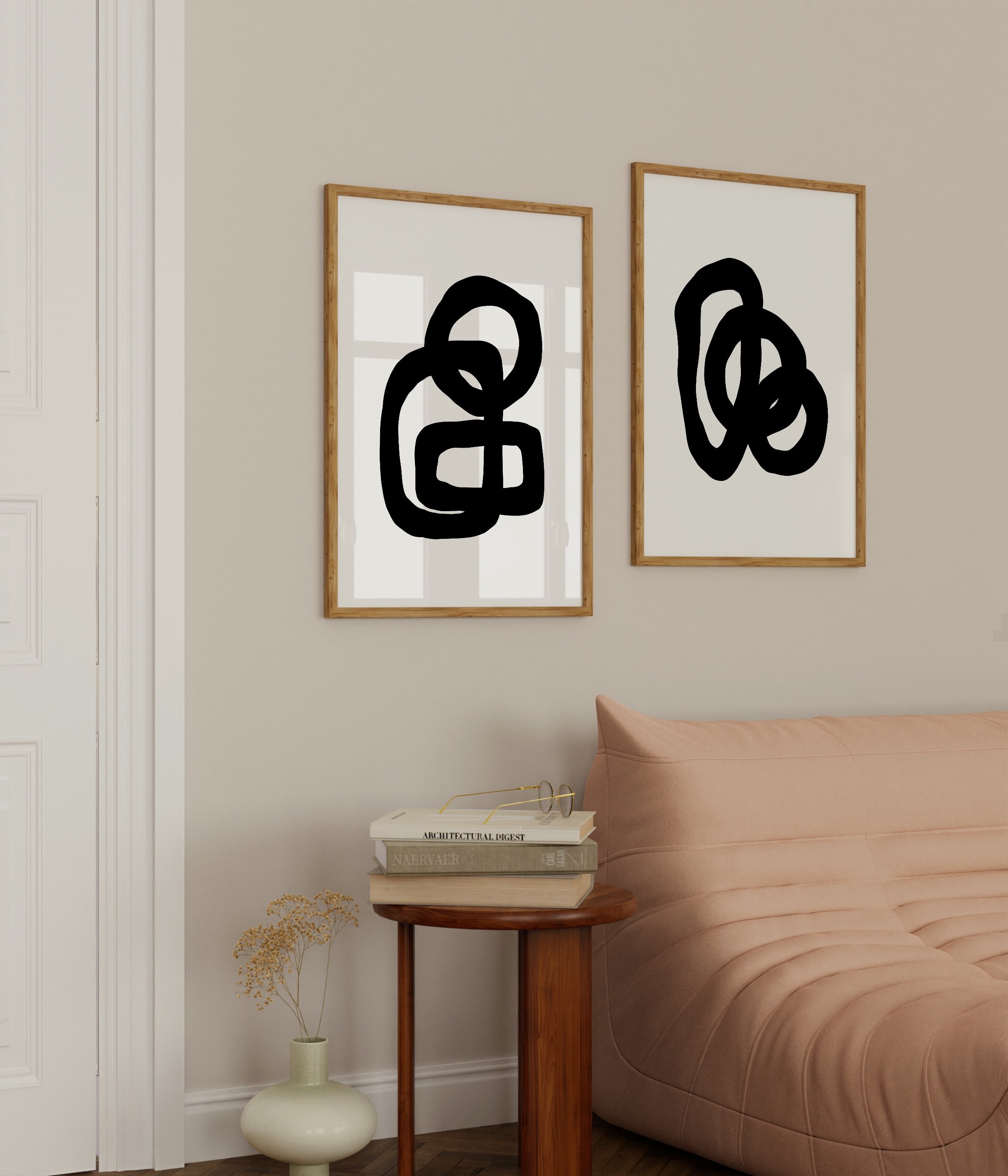 Minimalist abstract art prints featuring bold black loops on white backgrounds, framed in white and displayed as a contemporary art duo.