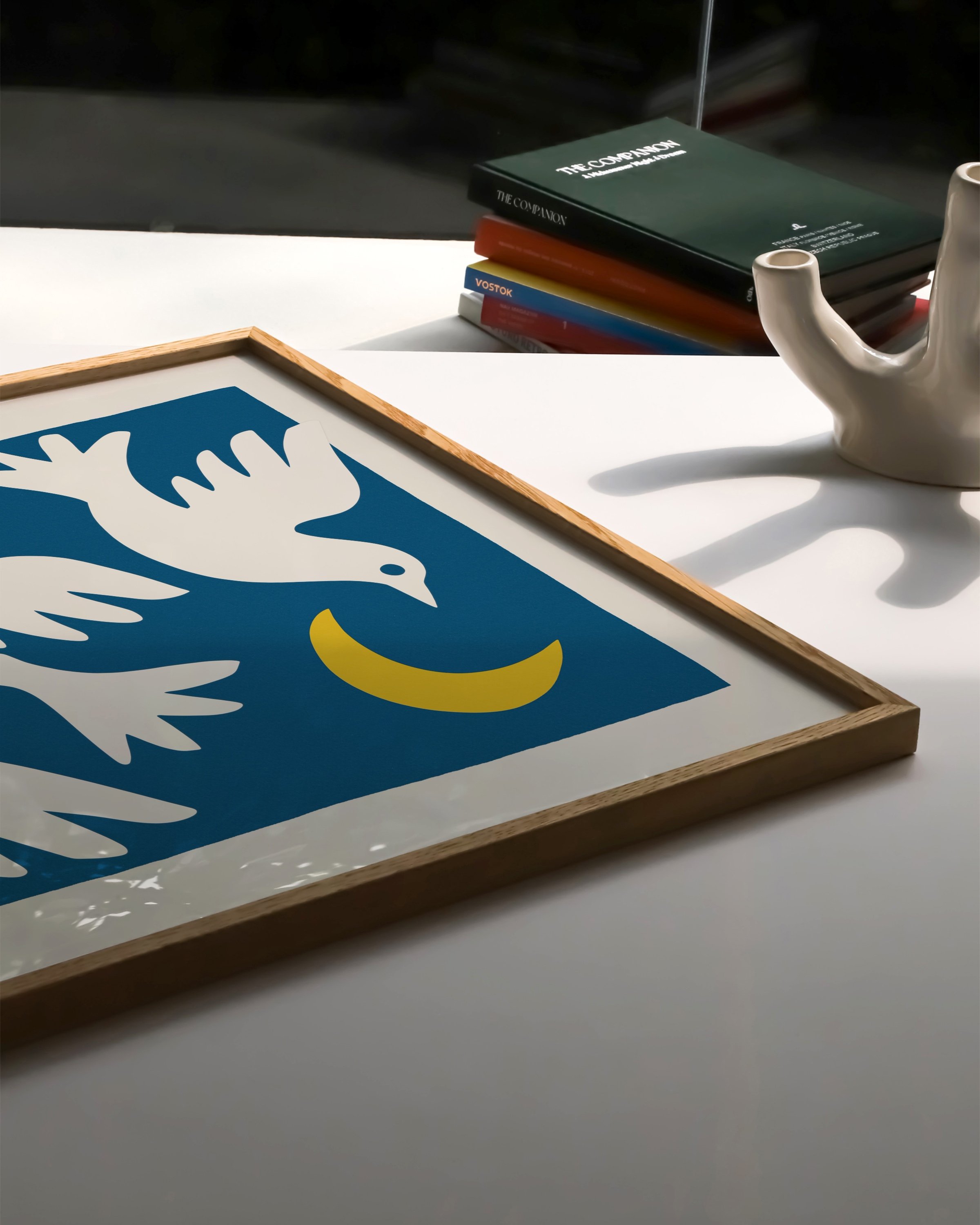 featuring three white doves flying around a yellow crescent moon on a bold blue background.