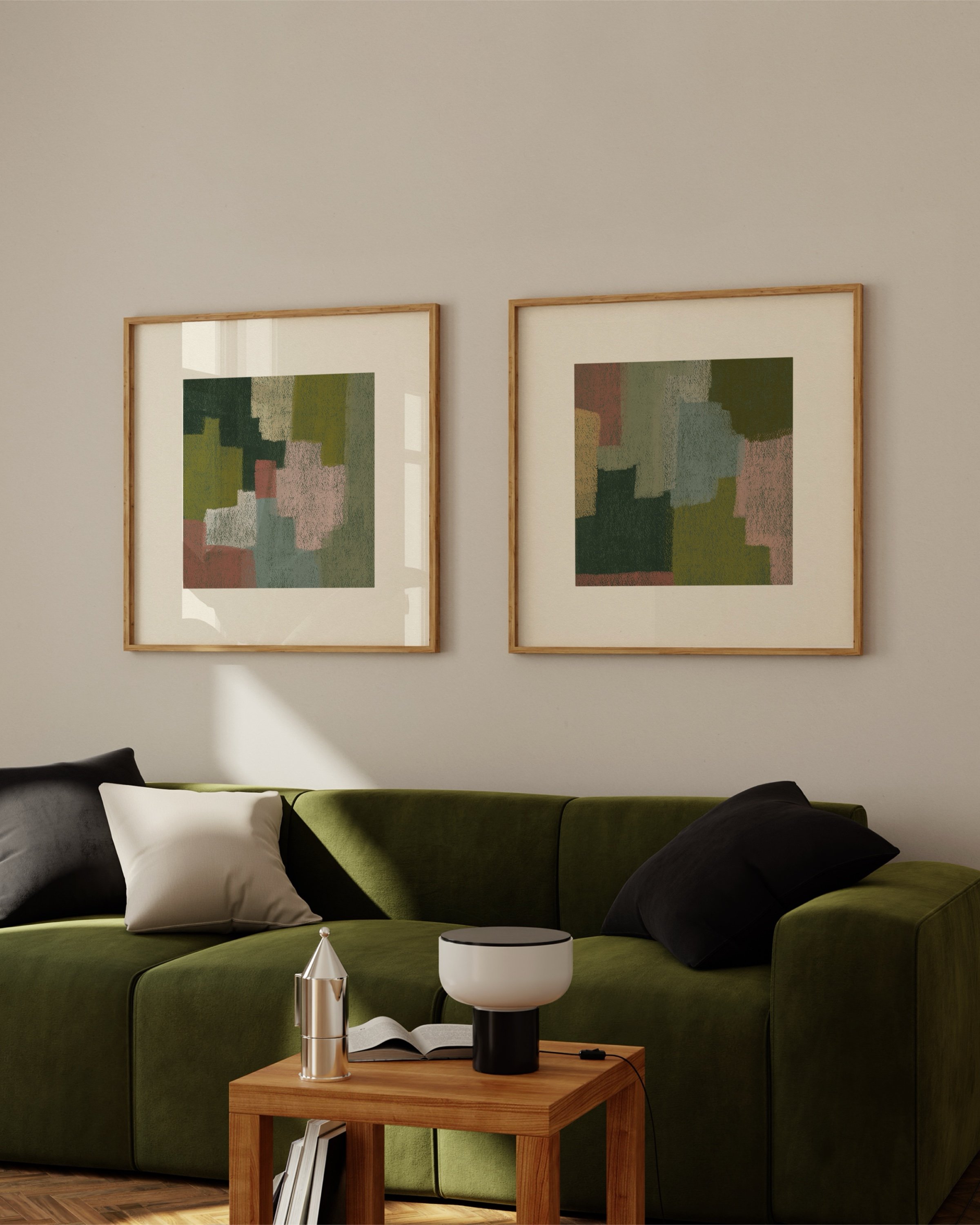 Set of two abstract wall art prints in earthy tones, displayed above a green sofa in a cozy living room.
