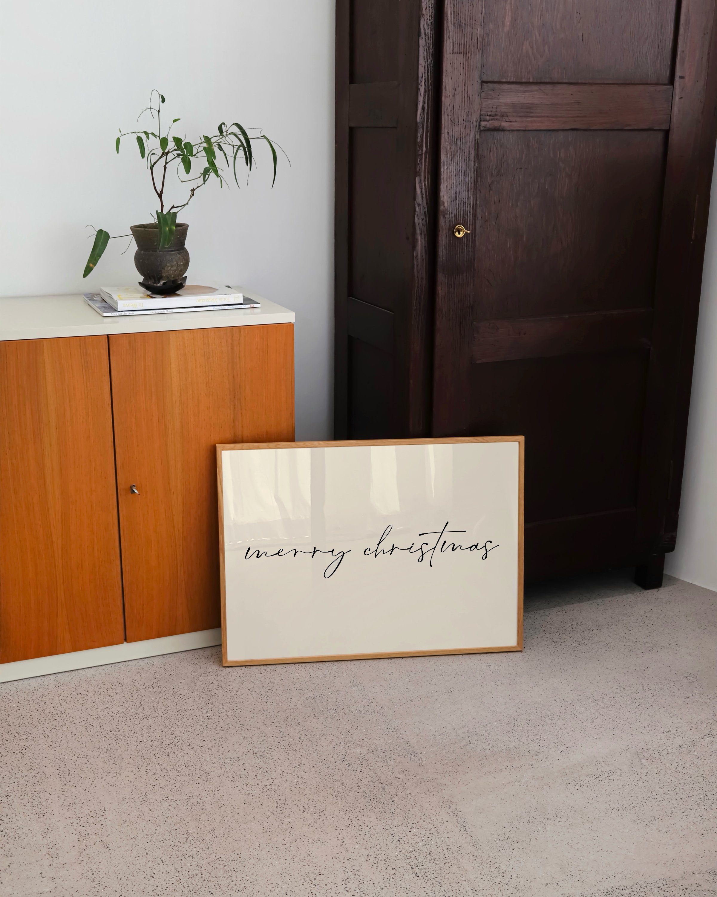 Minimalist Merry Christmas wall art with black calligraphy on a light background
