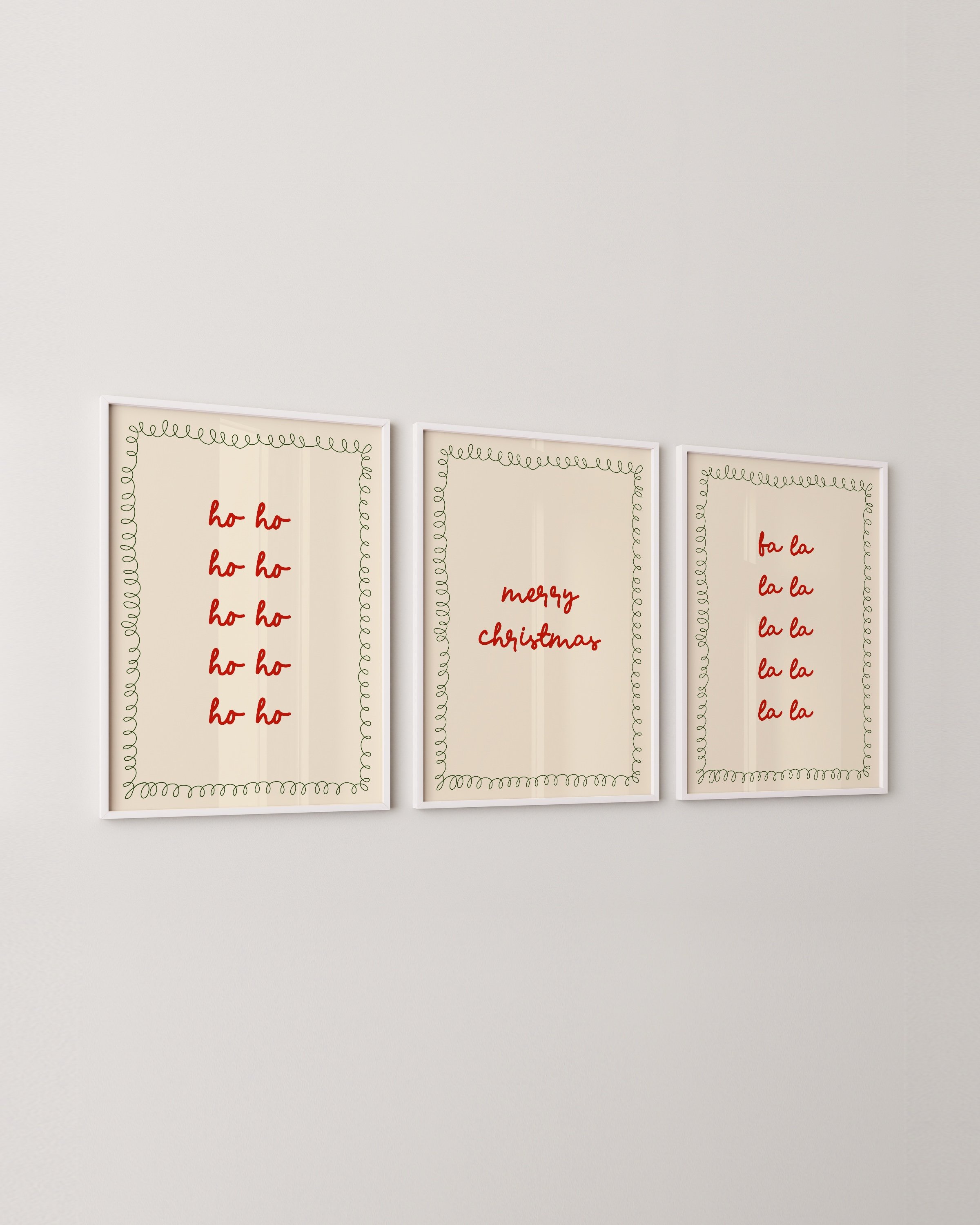 Set of three Christmas wall art prints with red typography reading “Ho Ho Ho,” “Merry Christmas,” and “Fa La La,” bordered by green doodles.