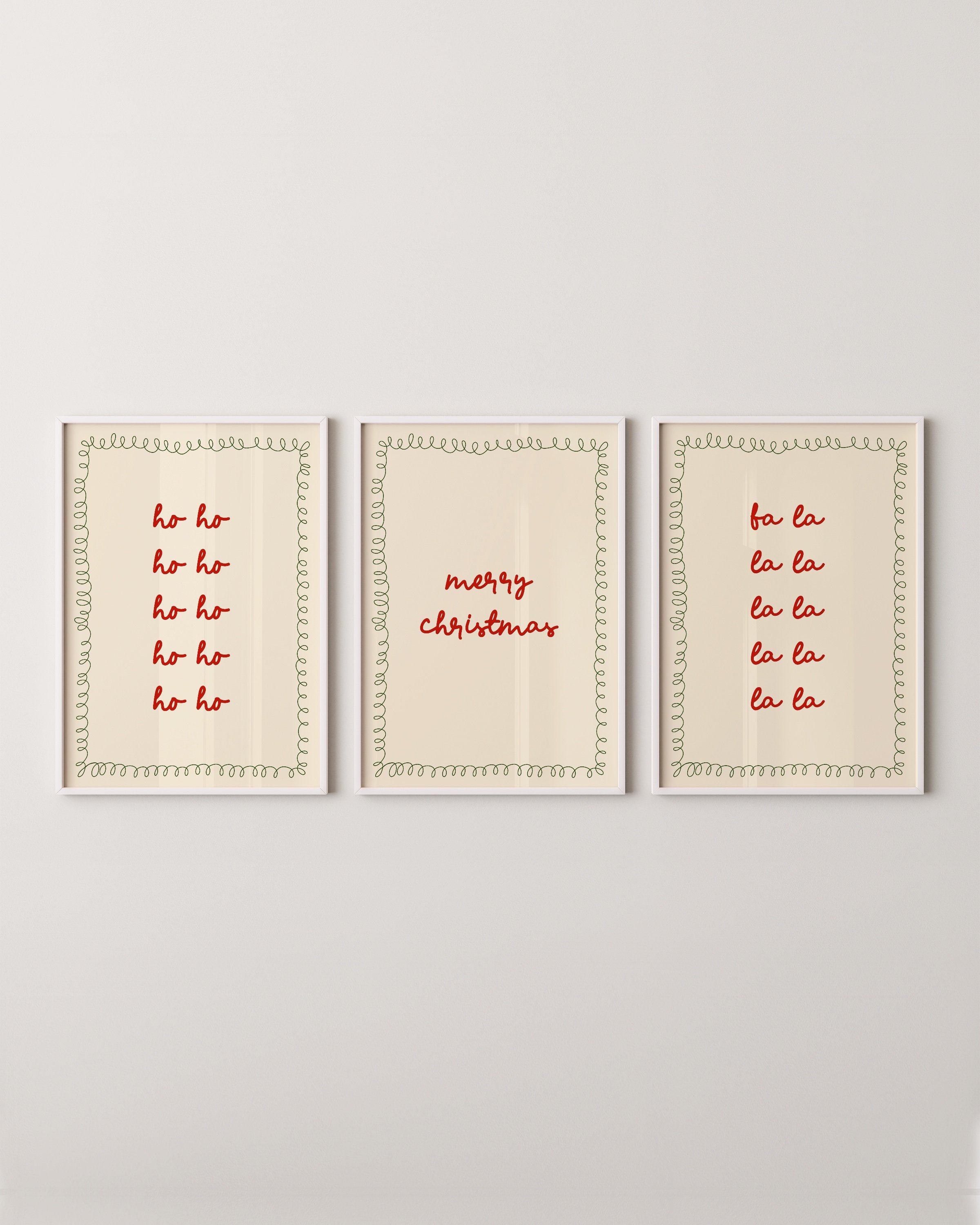 Set of three Christmas wall art prints with red typography reading “Ho Ho Ho,” “Merry Christmas,” and “Fa La La,” bordered by green doodles.
