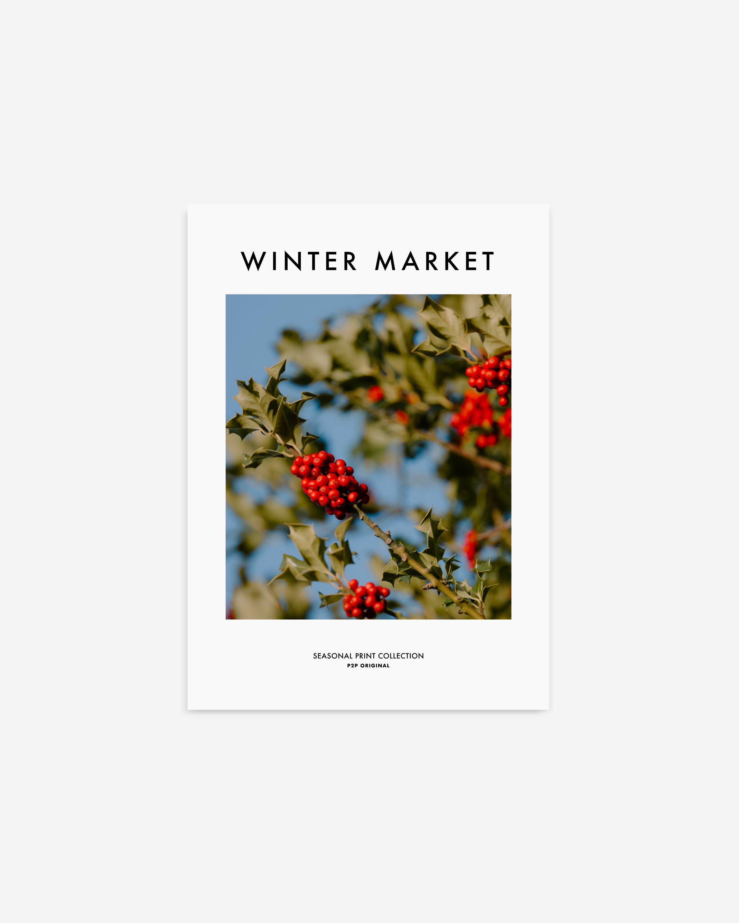 Vibrant photograph of red holly berries with green leaves set against a bright blue sky, perfect for festive holiday decor.