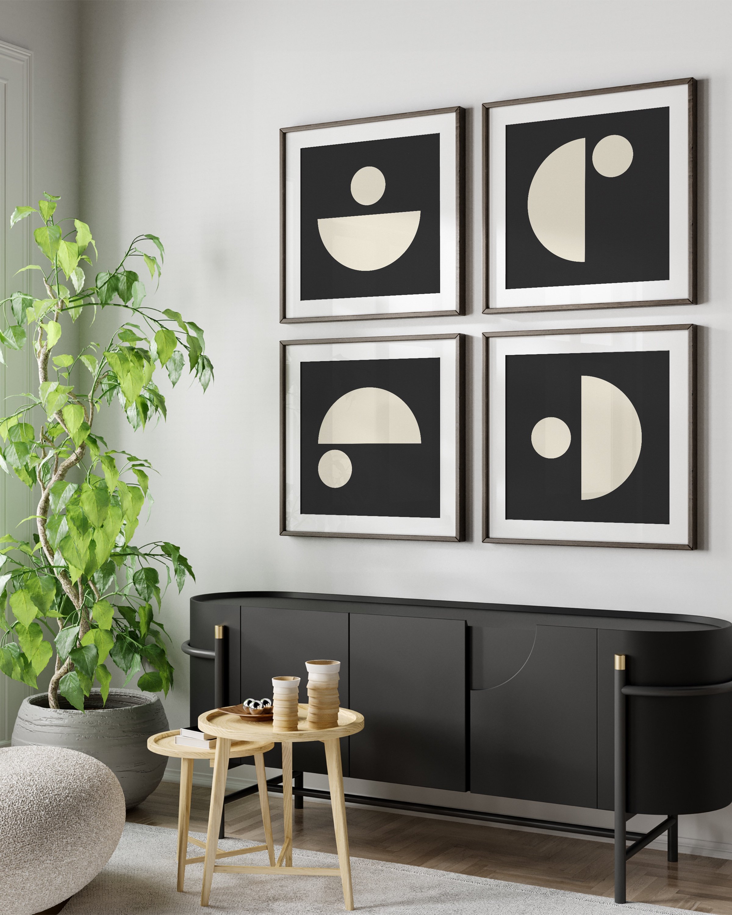 Modern minimalist geometric wall art set featuring black and cream abstract shapes, displayed in wooden frames on a neutral wall with a cozy armchair and natural decor elements.