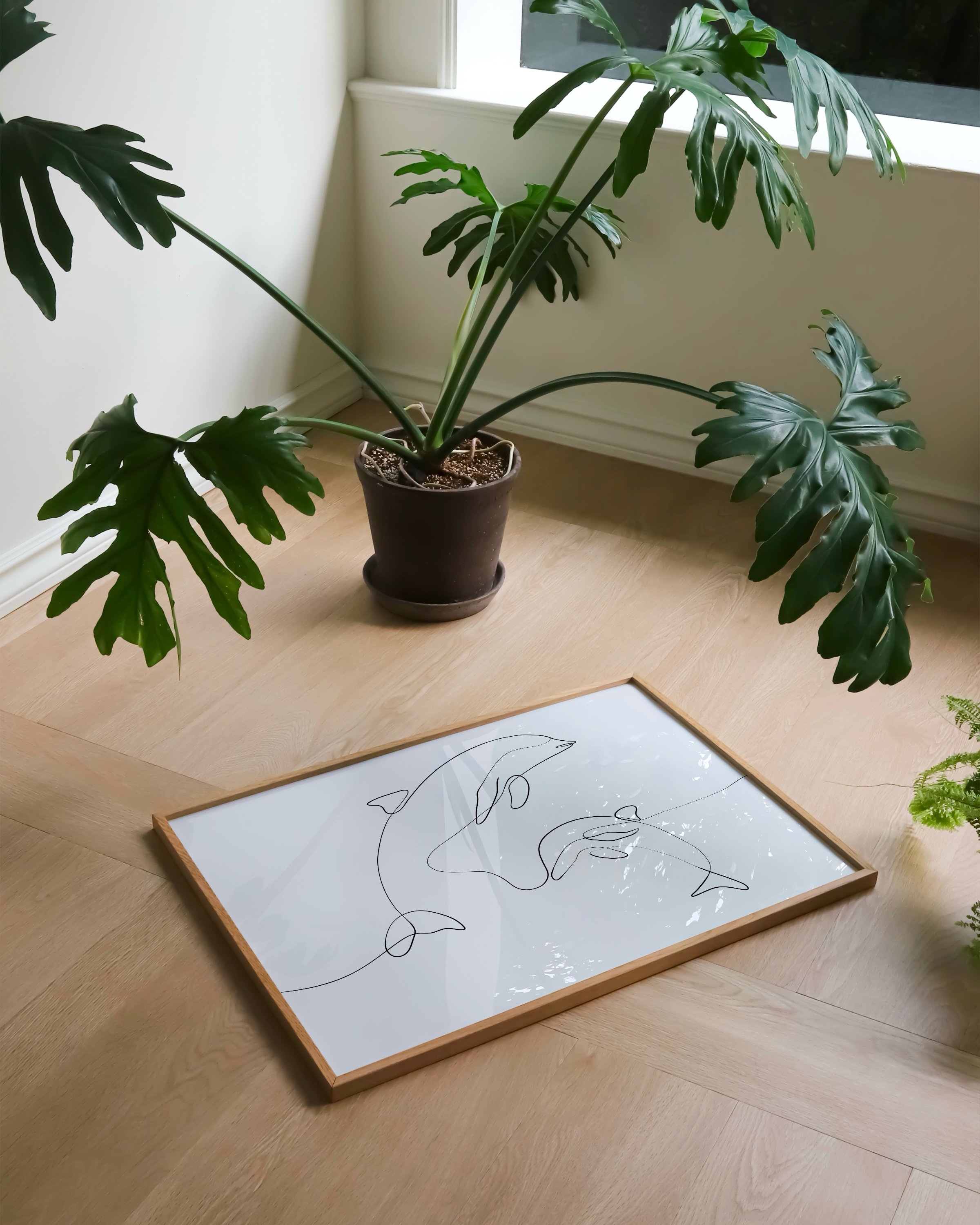 Minimalist line art print featuring dolphins swimming, created in a continuous line style for an elegant marine decor addition.