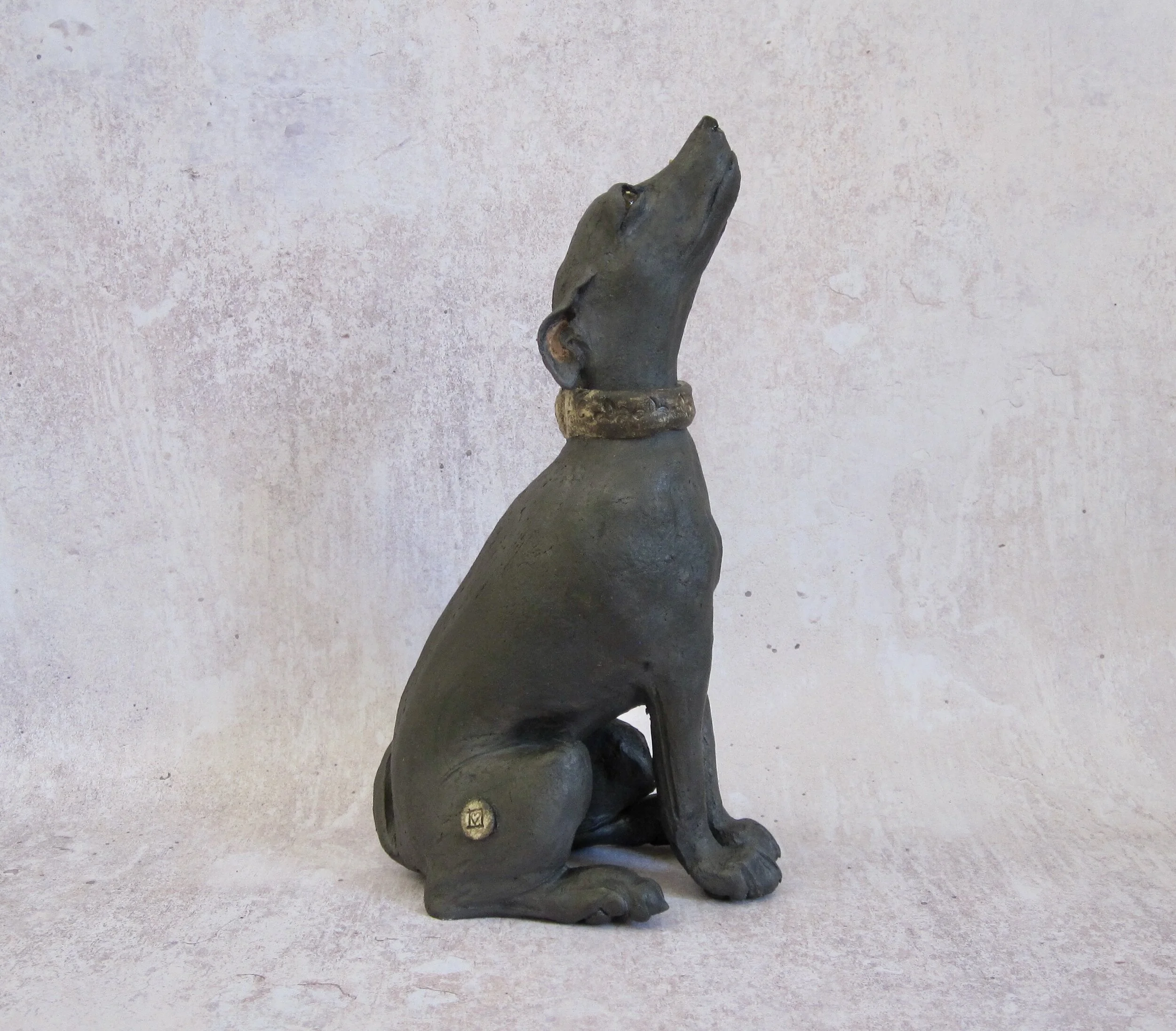 Individual handmade, sculpted black dog, side view